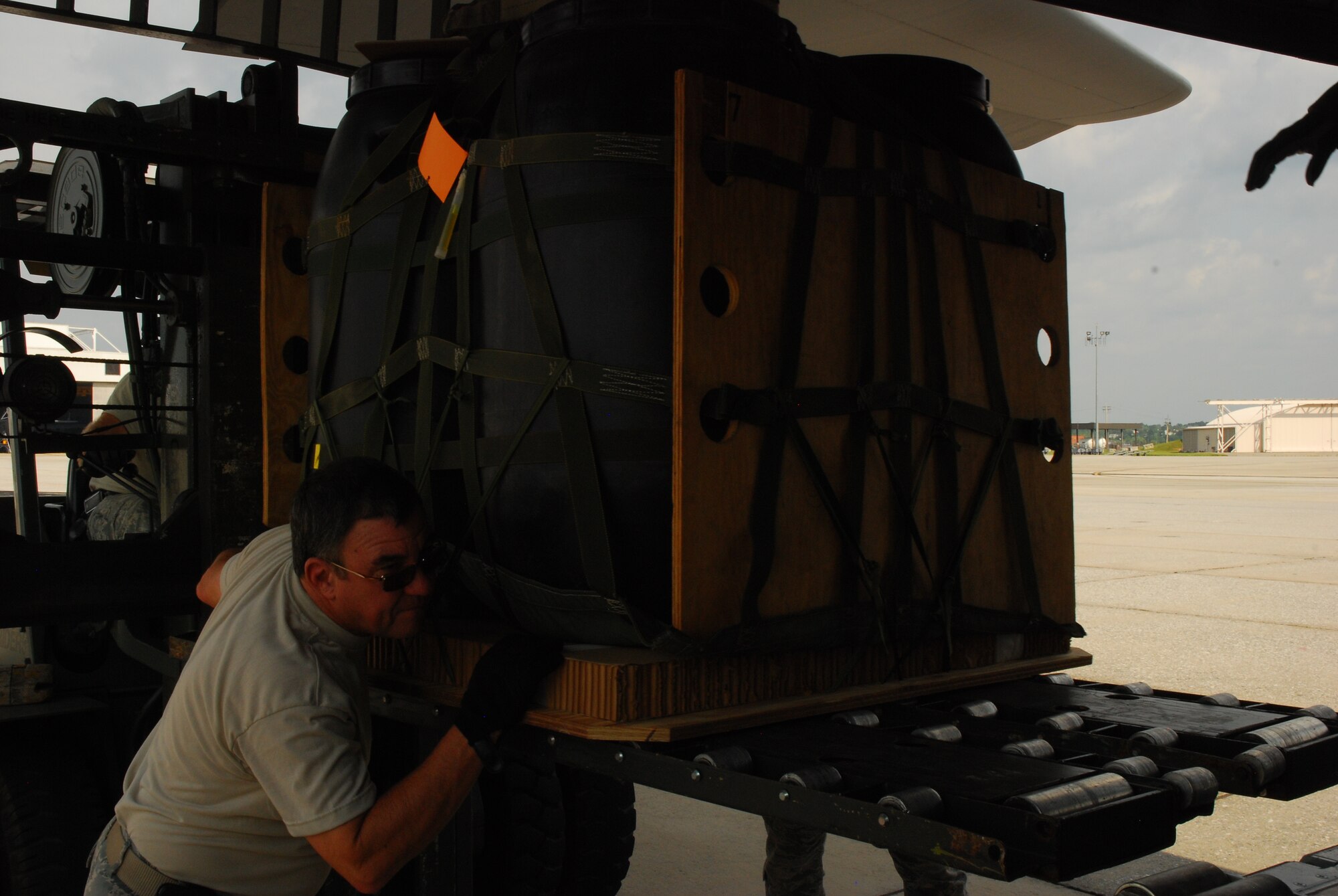 Tech. Sgt. Sam Farmer, 94th Airlift Wing aerial delivery flight, pushes a load of consolidated delivery systems (CDS) into the exterior of the C-130H aircraft. CDS bundles are used as a means of delivering equipment too heavy for the individual jumper to carry. Additionally, they can be utilized to supply airborne units or re-supply units on the ground. (U.S. Air Force photo/Airman 1st Class Chelsea Smith)