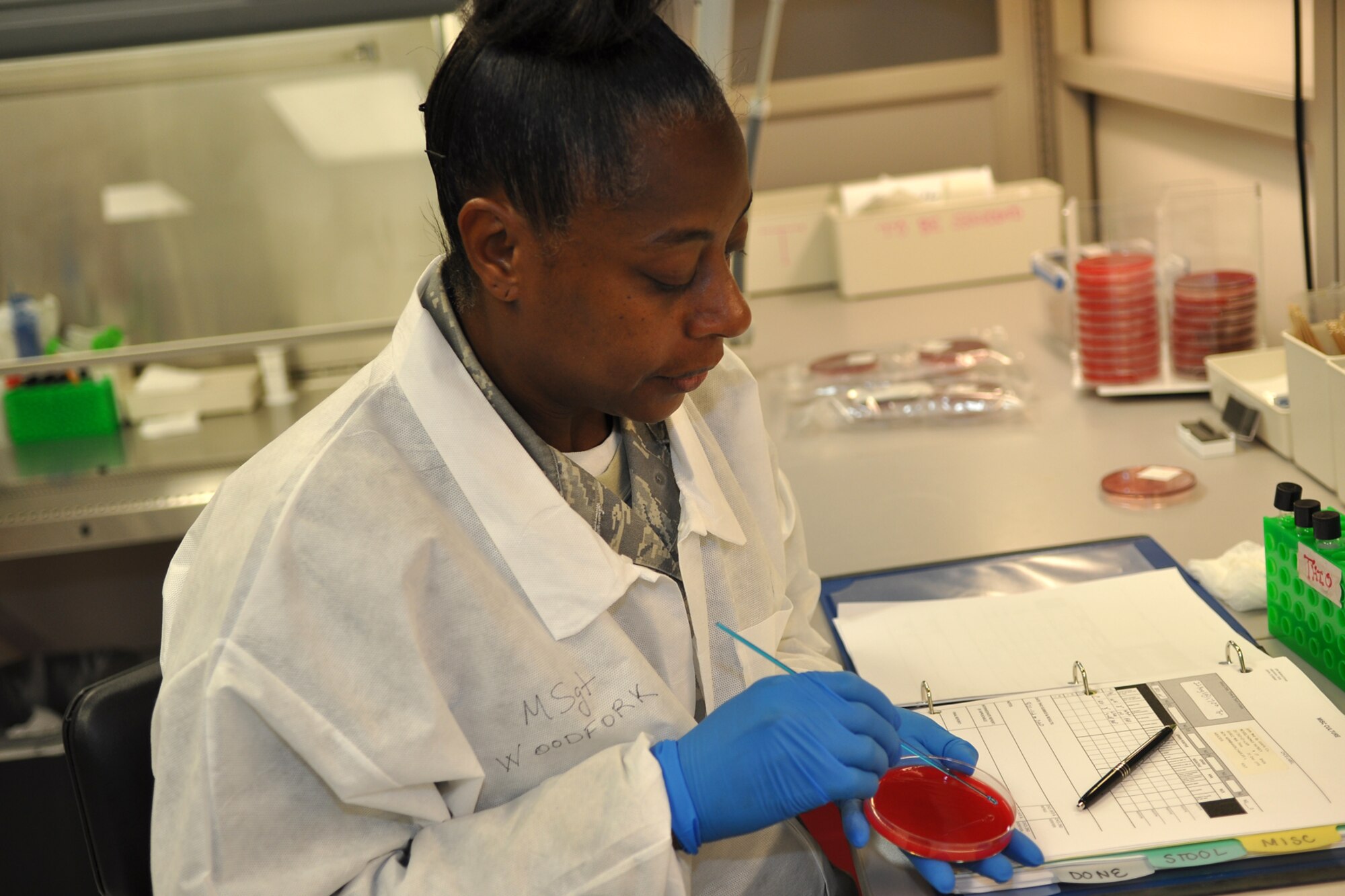 Master Sgt. Nordyica Woodfork, a laboratory technician assigned to the 307th Medical Squadron from Barksdale Air Force Base, La., spots several possibly different bacteria growths on an agar media plate in the bio lab at the U.S. Air Force Academy in Colorado Springs, Colo., Aug. 22, 2011. Woodfork isolated one of the shapes to place on a new plate to store for a 24-hour growth period. She was part of a group of 307th Bomb Wing Airmen who were at the Academy as part of their annual tour training, Aug. 13-26, 2011. (U.S. Air Force photo by Betty Stephens/Released)