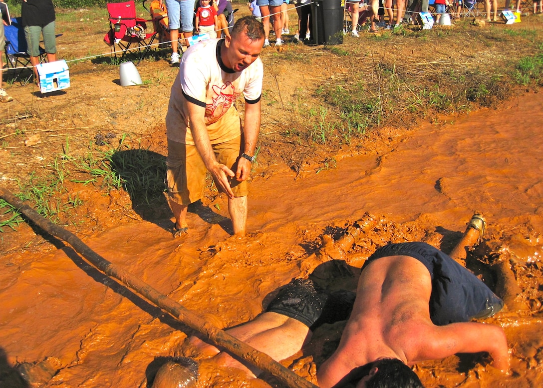 Staff Sgt. James Alston (left), a Reserve Marine on staff with Wounded Warrior Battalion East at Camp Lejeune, N.C., shouts encouragement to participants at the Marine Mud Challenge in Belmont, N.C.  Reserve Marines from throughout North Carolina volunteered to help out at this fifth annual event, which attracted more than 800 civilians and military members this year. (Photo by Maj. Paul Greenberg)