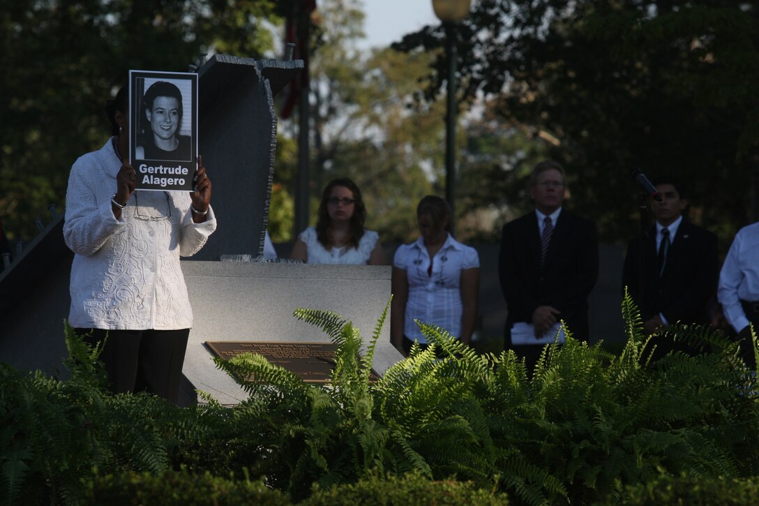 A participant of the Patriot Day 2011 ceremony holds a photo of one of the many victims who lost their lives in the Sept. 11, 2011 terrorist attack on the World Trade Center during the 10th anniversary ceremony at the Memorial Beam in the Lejeune Memorial Gardens, Sept. 11. Gertrude Alagero was one of nine profile pictures memorialized during the ceremony, their short biographies of their lives leading up to Sept. 11 were read to the attendants.