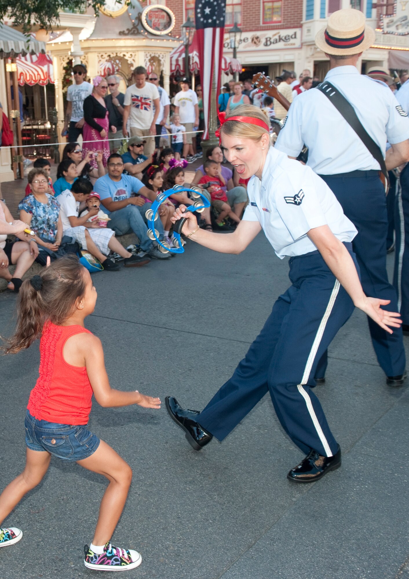 Airmen Karmen Suter gives a young child a huge thrill as they dance away to "Ain't She Sweet" during the parade down Mainstreet Disneland with Dixieland Tailgaters of the 562nd Air Force Band. July 11, 2011

Photo by TSgt Chuck Hatton