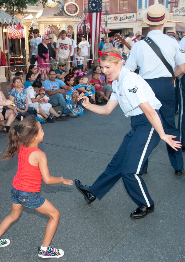 Airmen Karmen Suter gives a young child a huge thrill as they dance away to "Ain't She Sweet" during the parade down Mainstreet Disneland with Dixieland Tailgaters of the 562nd Air Force Band. July 11, 2011

Photo by TSgt Chuck Hatton
