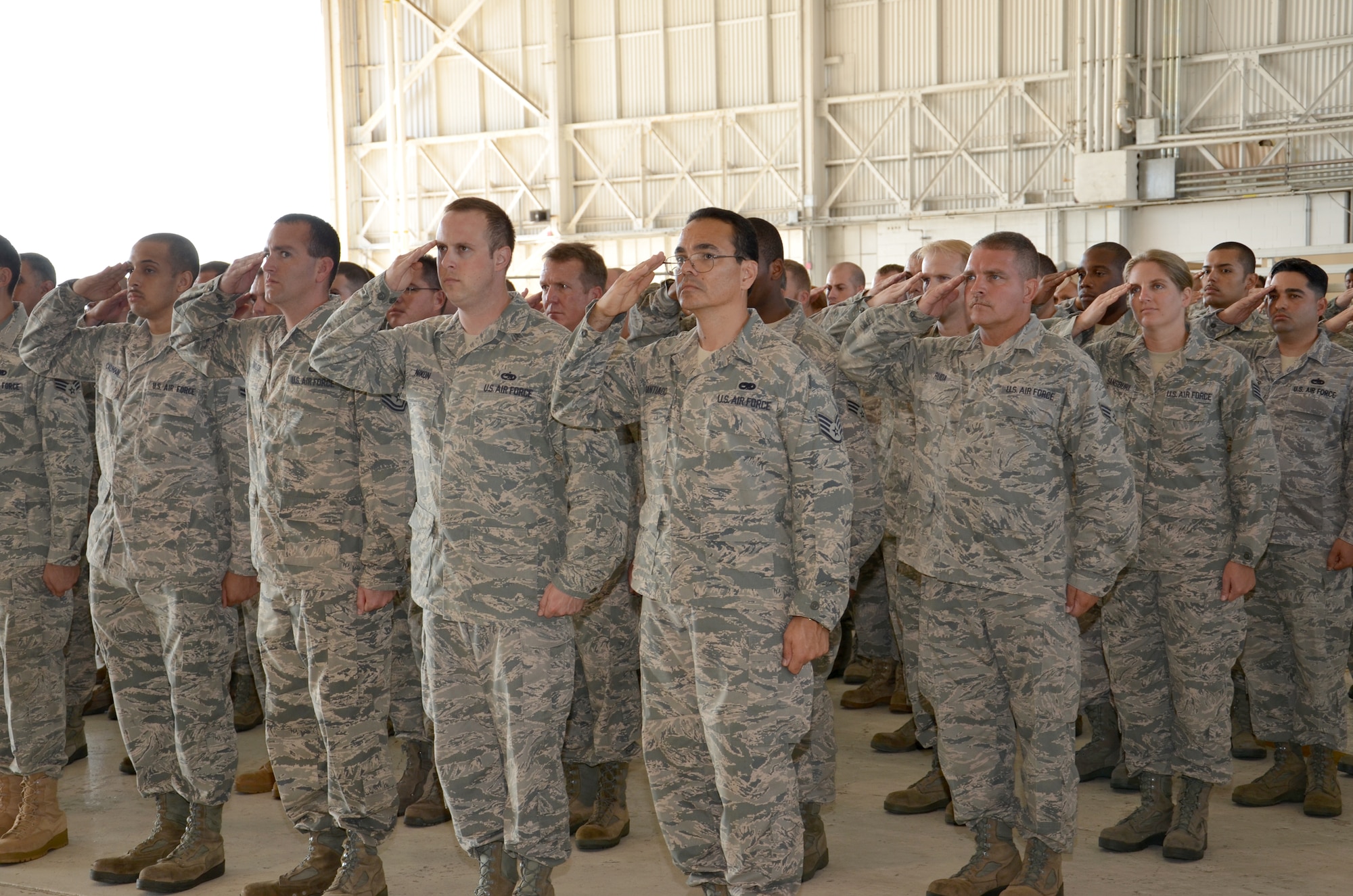 PATRICK AIR FORCE BASE, Fla. - Airmen of the 920th Rescue Wing salute their new commander, Col. Jeffrey L. Macrander, after he accepts the 920th Rescue Wing flag from Brig. Gen. Frank Padilla, 10th Air Force Commander, Naval Station Joint Reserve Base, Texas, at a change-of-command ceremony in an aircraft hangar here Sept. 11, 2011. Colonel Macrander replaced Robert L. Dunn as the Air Force Reserve combat-search-and-rescue wing's new commander. (U.S. Air Force photo/Staff Sgt. Anna-Marie Wyant)