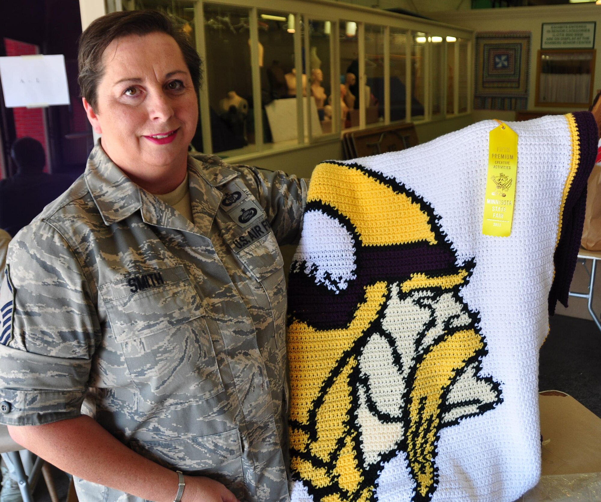 Master Sgt. Shirley Smith, 934th Operations Support Squadron, poses with her award-winning afghan blanket at the 2011 Minnesota State Fair.  (Air Force photo/Tech. Sgt. Jeffrey Williams)