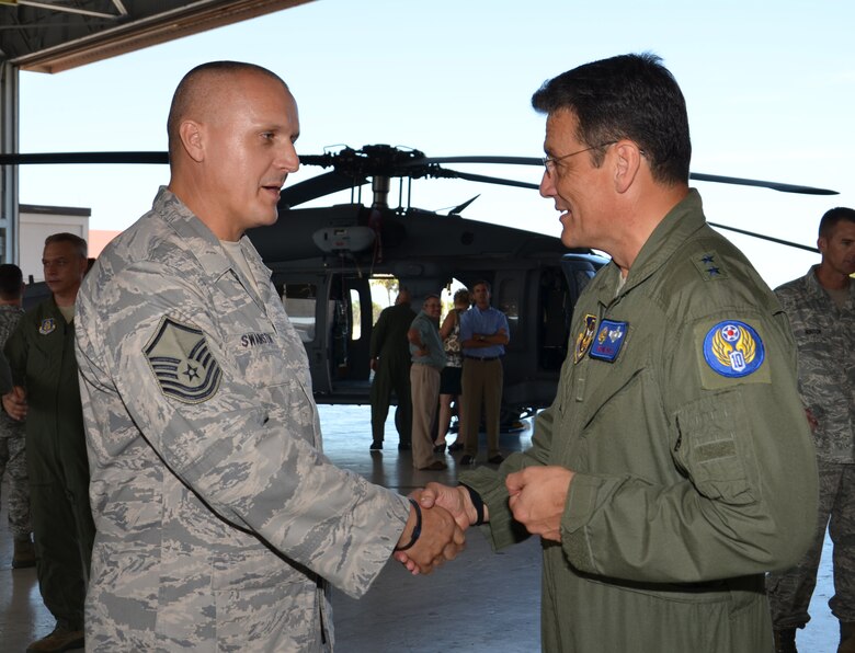 PATRICK AIR FORCE BASE, Fla. -- Maj. Gen. Frank Padilla (right), 10th Air Force commander, awards a coin to Master Sgt. Kenneth Swainston, a 920th Rescue Wing traditional Reservist, at Hangar 750 here Sept. 11, 2011. Swainston received the coin for helping local law enforcement rescue a stabbing victim from a car in the Indian River in Melbourne, Fla., just a few miles from the base.   