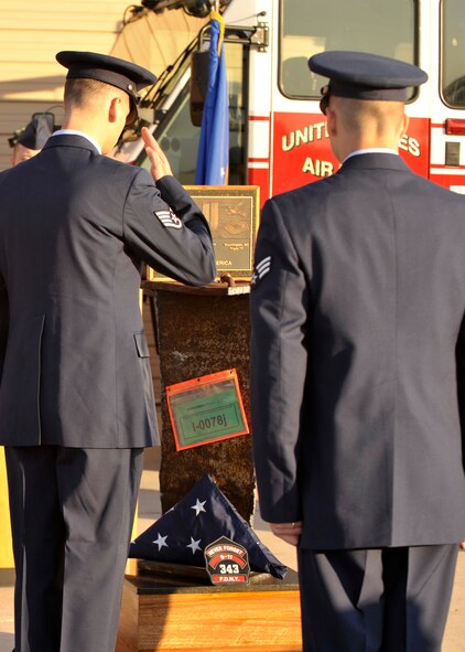 A member of the Cannon Air Force Base honor guard salutes the American flag after folding it and placing it upon the newly dedicated September 11, 2001 memorial at Cannon Air Force Base, N.M., Sept. 11, 2011. The monument will be placed at the Cannon Air Force Base Fire Department for all to see and remember. (U.S. Air Force Photo by Airman 1st Class Ericka Engblom)