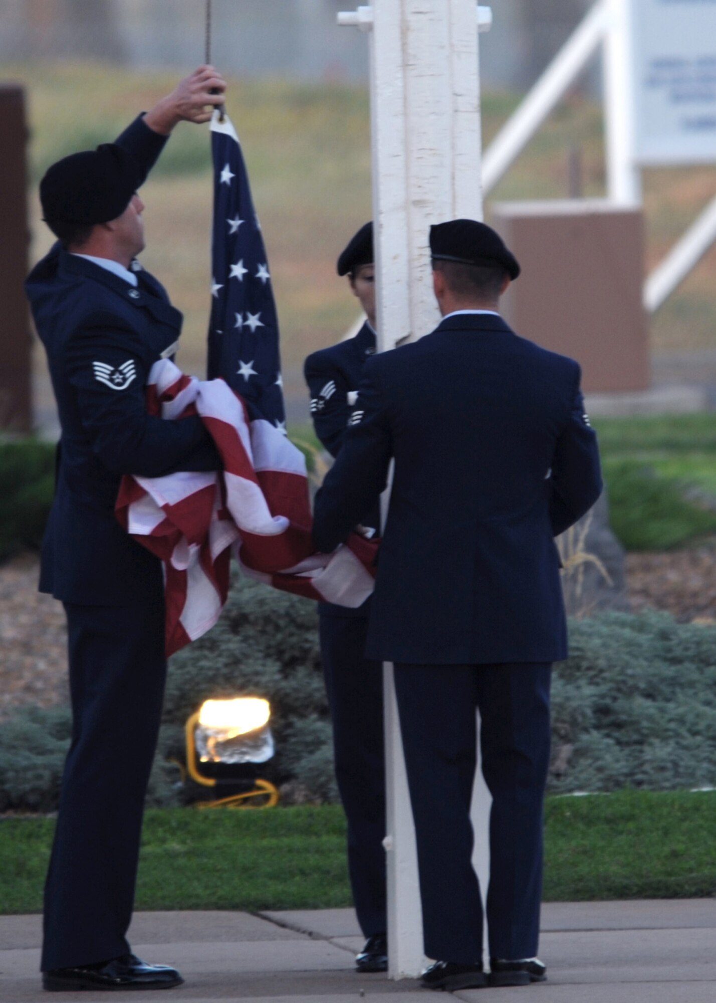 Members of 27th Special Operations Security Forces Squadron lower the American flag during the 10th anniversary of September 11th at Cannon Air Force Base, N.M., Sept. 11, 2011.  The flag will become a permanent part of a monument honoring the victims of September 11, 2001 at the Cannon Air Force Base Fire Department.  (U.S. Air Force photo by Senior Airman James Bell)