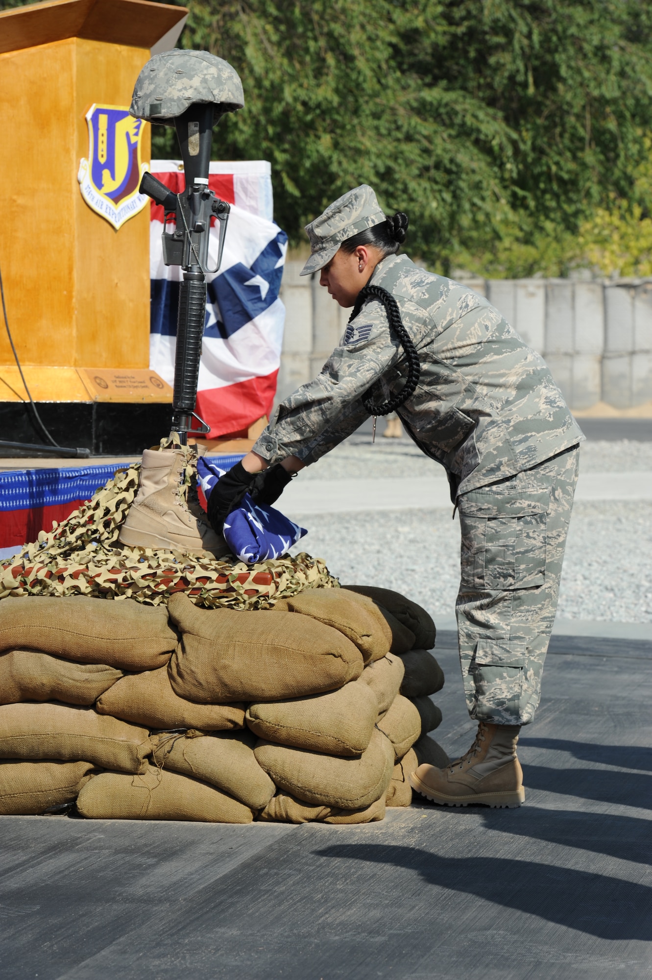 A member of the 376th Air Expeditionary Wing Honor Guard places a folded U.S. flag at the base of a Battlefield Cross Memorial during the 9/11 remembrance ceremony at the Transit Center at Manas, Kyrgyzstan, Sept. 11. Distinguished visitors from 16 different countries attended the ceremony including Kyrgyz Republic President Roza Otunbayeva. The  Memorial was placed to honor the service members who gave their life in Operations Iraqi and Enduring Freedom. (U.S. Air Force photo/Tech. Sgt. Hank Hoegen)