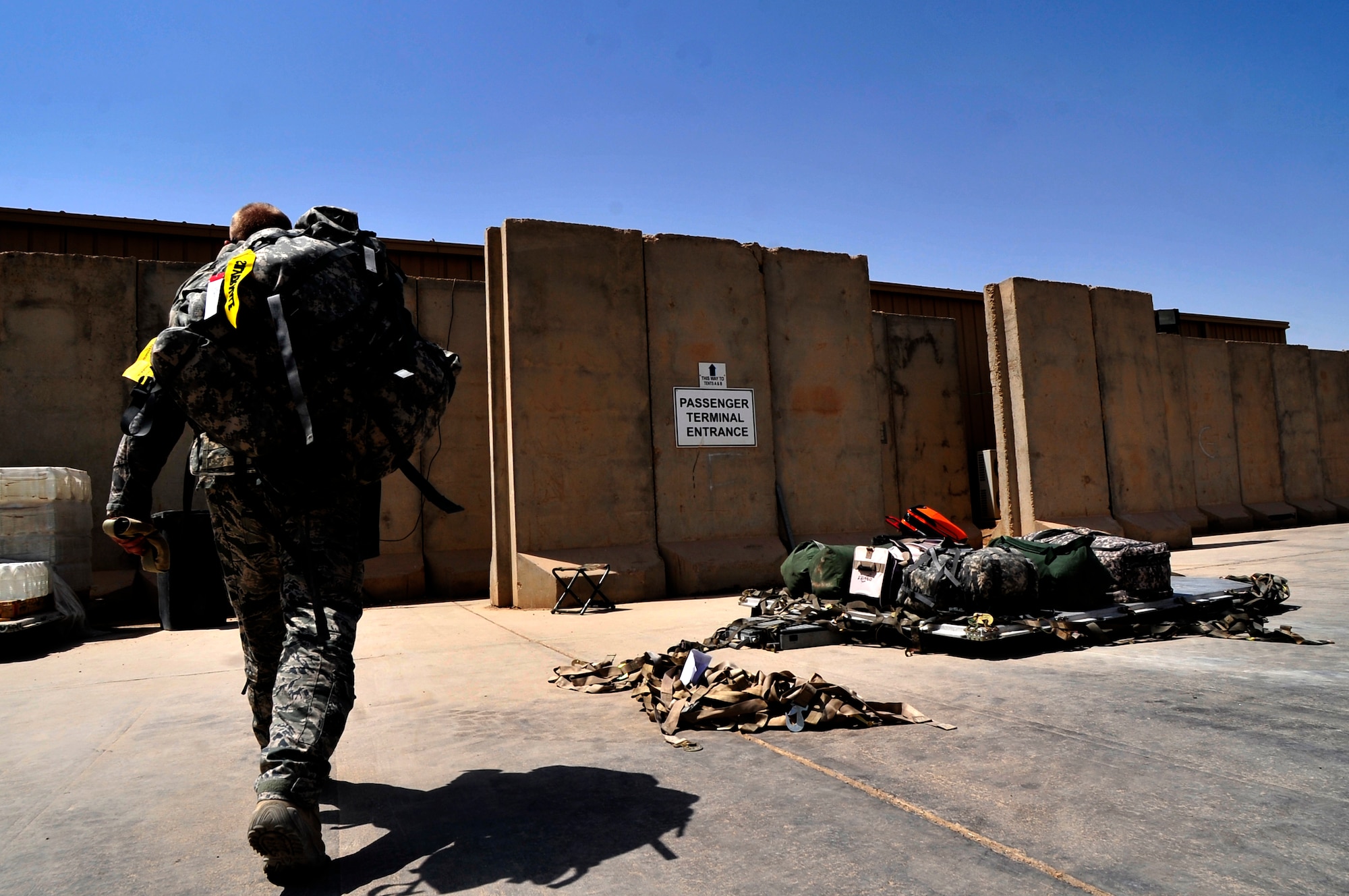 A soldier carries his gear into the Ali Base passenger terminal on Aug. 26, 2011. Ali Base passenger terminal, the southern aerial hub of Iraq, processes approximately 5,000 passengers and 850,000 pounds of cargo each month. (U.S. Air Force photo/Master Sgt. Cecilio Ricardo)