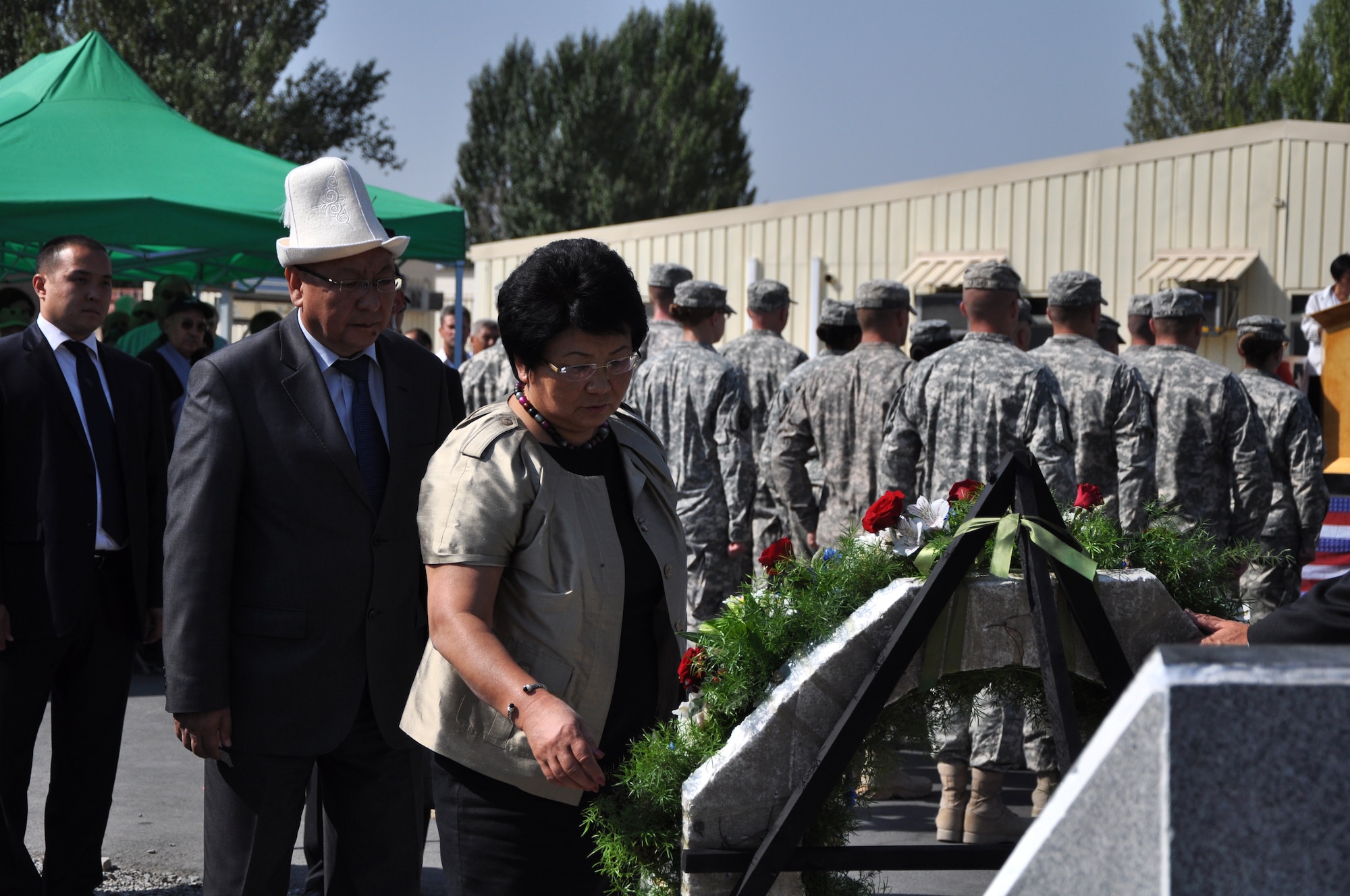 Kyrgyz Republic President Roza Otunbayeva views a wreath honoring those who died in the terrorist attacks of 9/11, during the Remembrance Ceremony at the Transit Center at Manas, Kyrgyzstan, Sept. 11. Otunbayeva spoke during the 60-minute ceremony and later visited the Pete Ganci Heritage Hall, which featured a number of 9/11 commemorative videos and displays, including a New York Fire Department firefighter's helmet from 9/11.