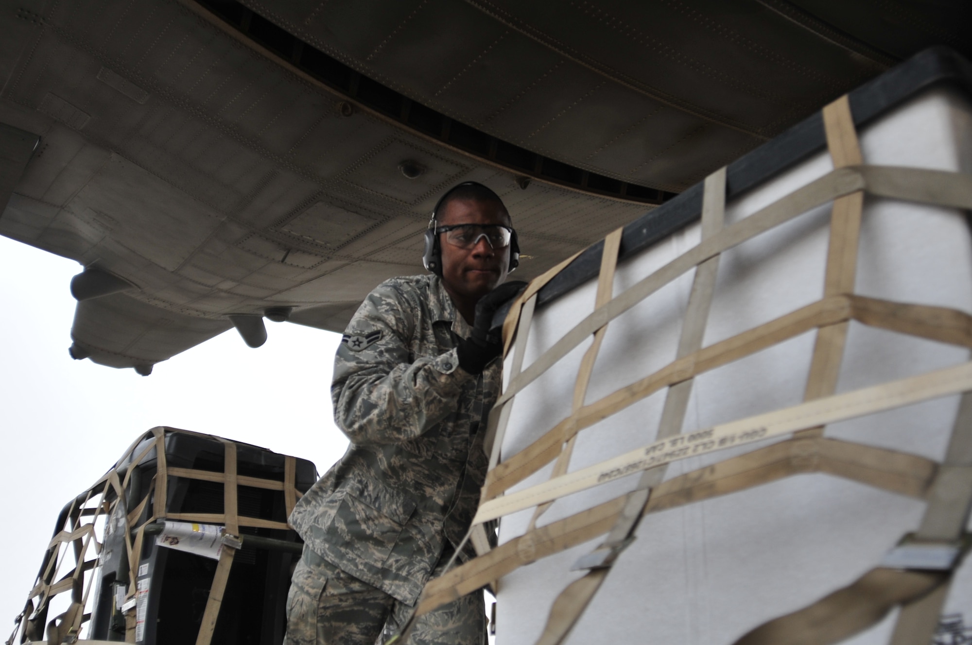 Airman 1st Class Stephen China pushes a pallet of cargo onto a C-130 Hercules, cargo aircraft at Ali Base, Iraq on Aug. 26, 2011.  Airman China is based out of Yokota Air Base, Japan and his hometown is Sumter, SC. (U.S. Air Force photo/Master Sgt. Cecilio Ricardo)