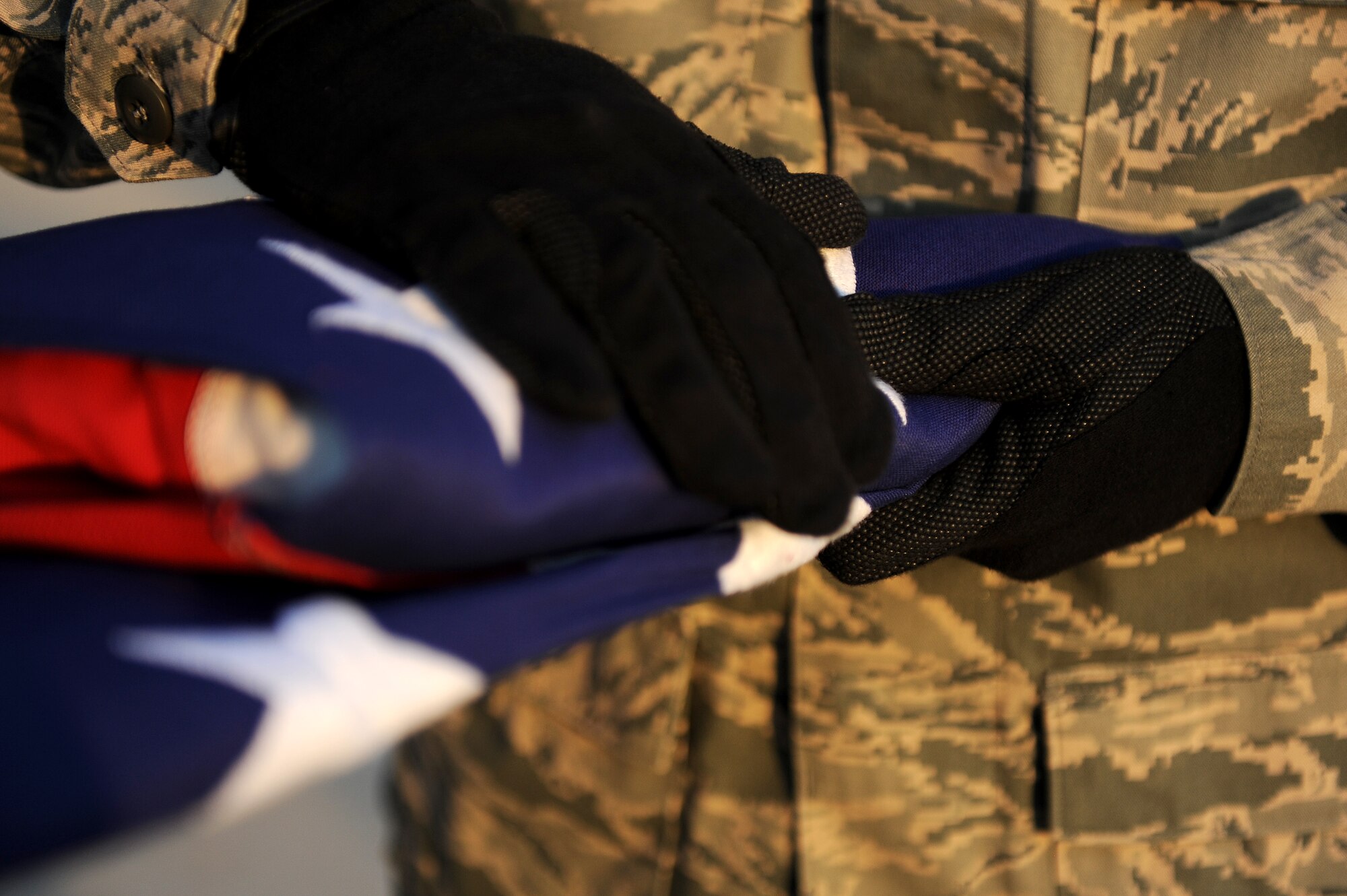 Staff Sgt. Anthony Inauen, 447th Expeditionary Communications Squadron, folds the U.S. flag to ceremonially retire the colors to Brig. Gen. Anthony Rock, 321st Air Expeditionary Wing commander, Sept. 11, 2011, in honor of the 10th anniversary of the attacks. More than 100 Soldiers, Sailors Airmen and civilians who took part in a remembrance march in full battle rattle. The two-mile march, split up into groups of 10, honored those who lost their lives during the attacks at the World Trade Center, the Pentagon and in Shanksville, Pa. (U.S. Air Force photo/Staff Sgt. Mike Meares)
