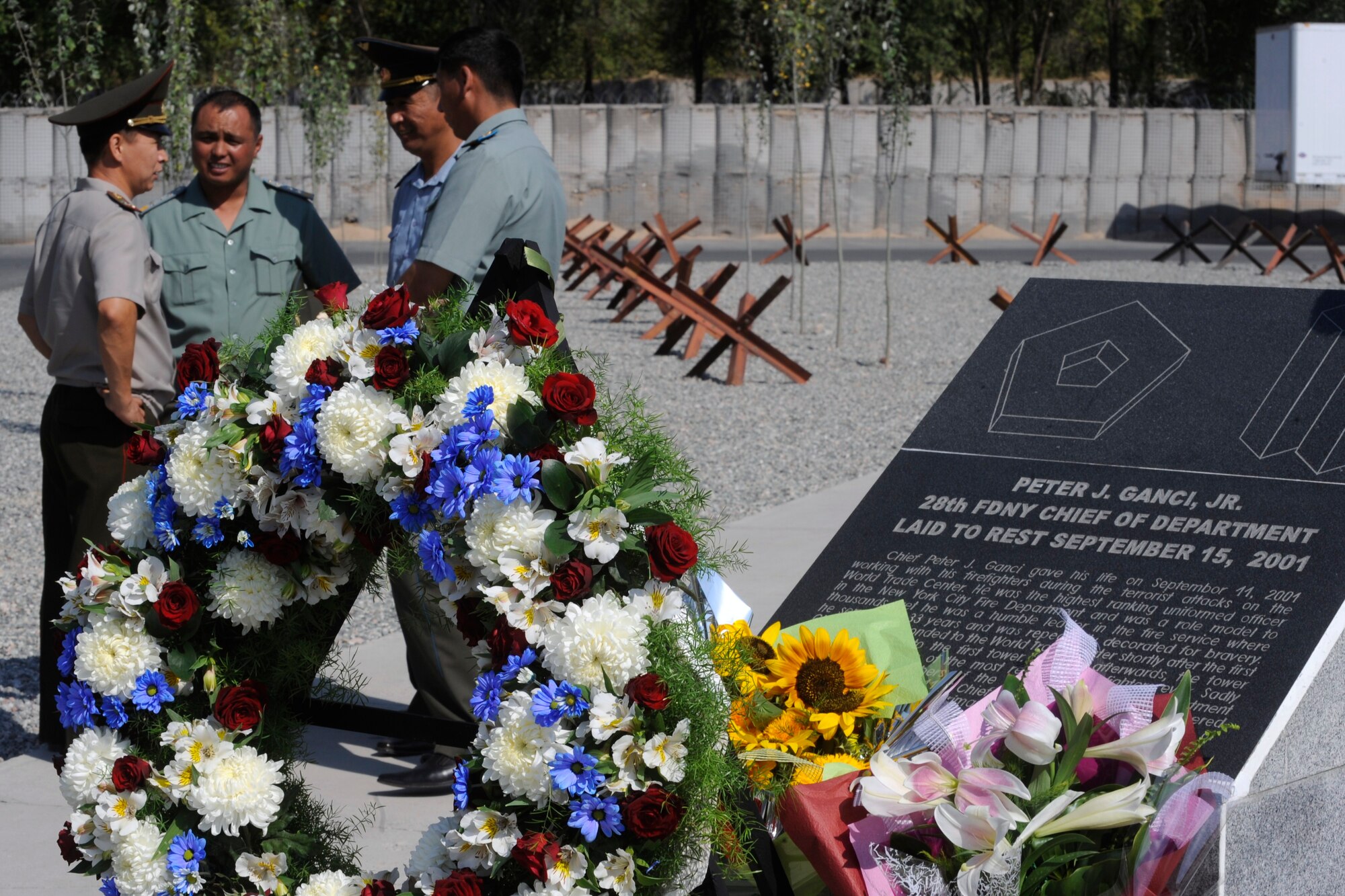 Foreign military dignitaries talk beside a Peter J. Ganci Jr. memorial at the Transit Center at Manas, Kyrgyzstan, following a 9/11 Remembrance Ceremony Sept. 11. Many distinguished guests attended the ceremony, including Kyrgyz Republic President Roza Otunbayeva, the U.S. Embassy Charge d’Affaires Larry Memmott and ranking members of the Kyrgyz Republic army. (U.S. Air Force photo/Tech. Sgt. Tammie Moore) 