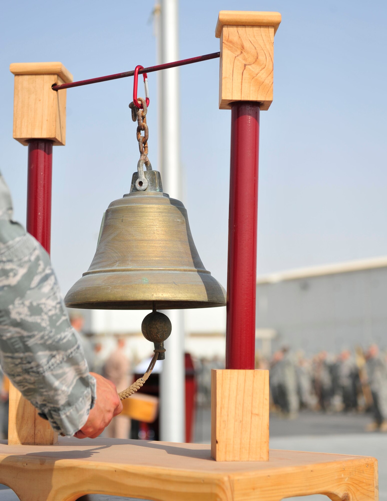 An Airman from the 380th Air Expeditionary Wing rings a bell to honor the lives lost on September 11, 2001, during a ceremony Sept. 11, 2011, at the wing 9/11 memorial. The Airmen of the 380th Air Expeditionary Wing and its mission partners honored the 10th anniversary of the attacks, remembering those who perished at the World Trade Center, the Pentagon, in Shanksville, Penn., and those who have given their lives in the name of freedom in the 10 years since, at a ceremony at the deployed wing. (U.S. Air Force photo/Tech Sgt. Patrick Mitchell)