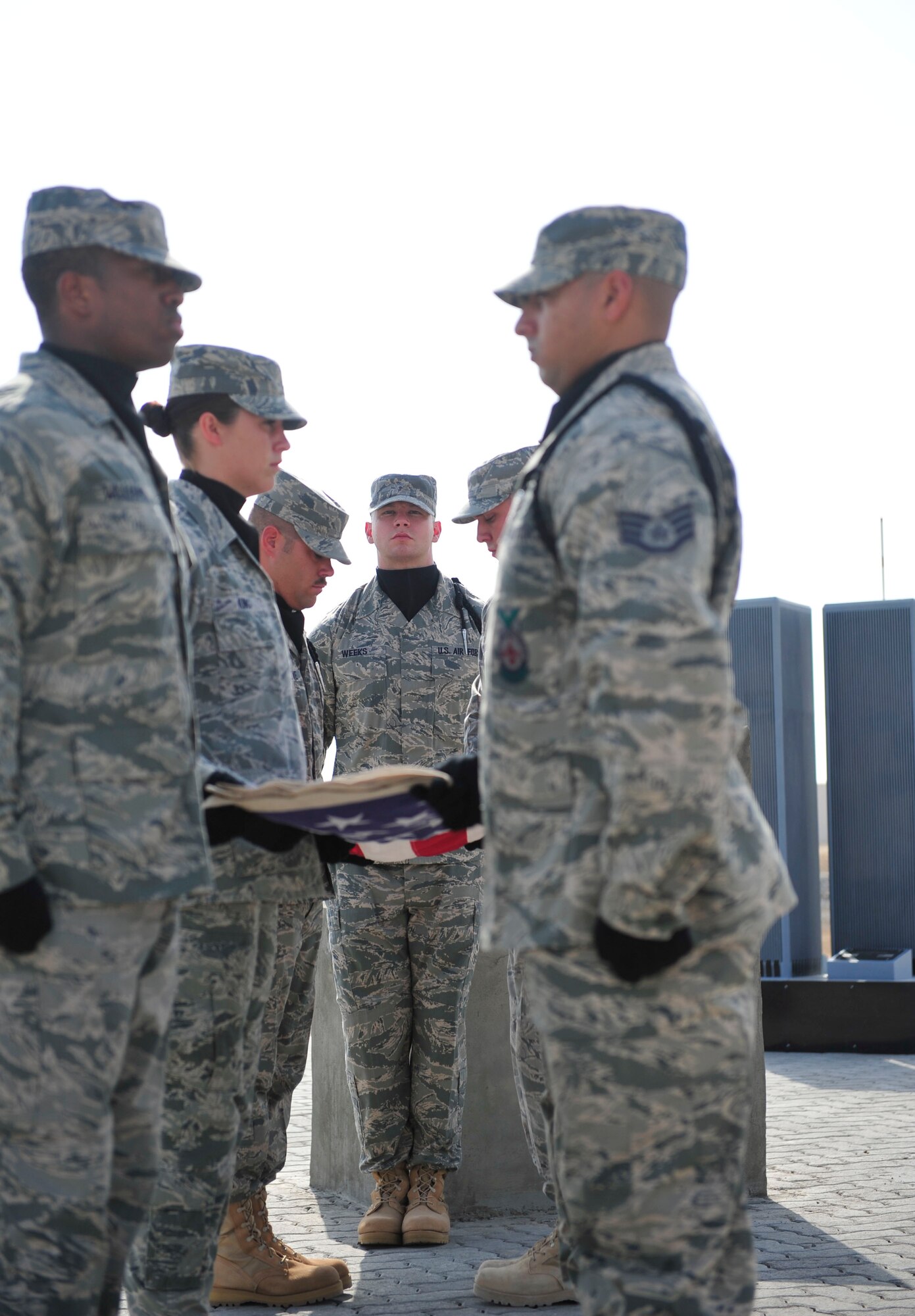 The 380th Air Expeditionary Wing Honor Guard executes a six-man flag folding during a 9/11 remembrance ceremony, Sept. 11, 2011, at the 380th AEW. The Airmen of the 380th AEW and its mission partners honored the 10th anniversary of the attacks and remembered those who perished at the World Trade Center, the Pentagon, in Shanksville, Penn., and those who have given their lives in the name of freedom in the 10 years since, at a ceremony Sept. 11, at the wing 9/11 memorial. The event began at 8:46 a.m., the exact time of the first attack. (U.S. Air Force photo/Tech Sgt. Patrick Mitchell)