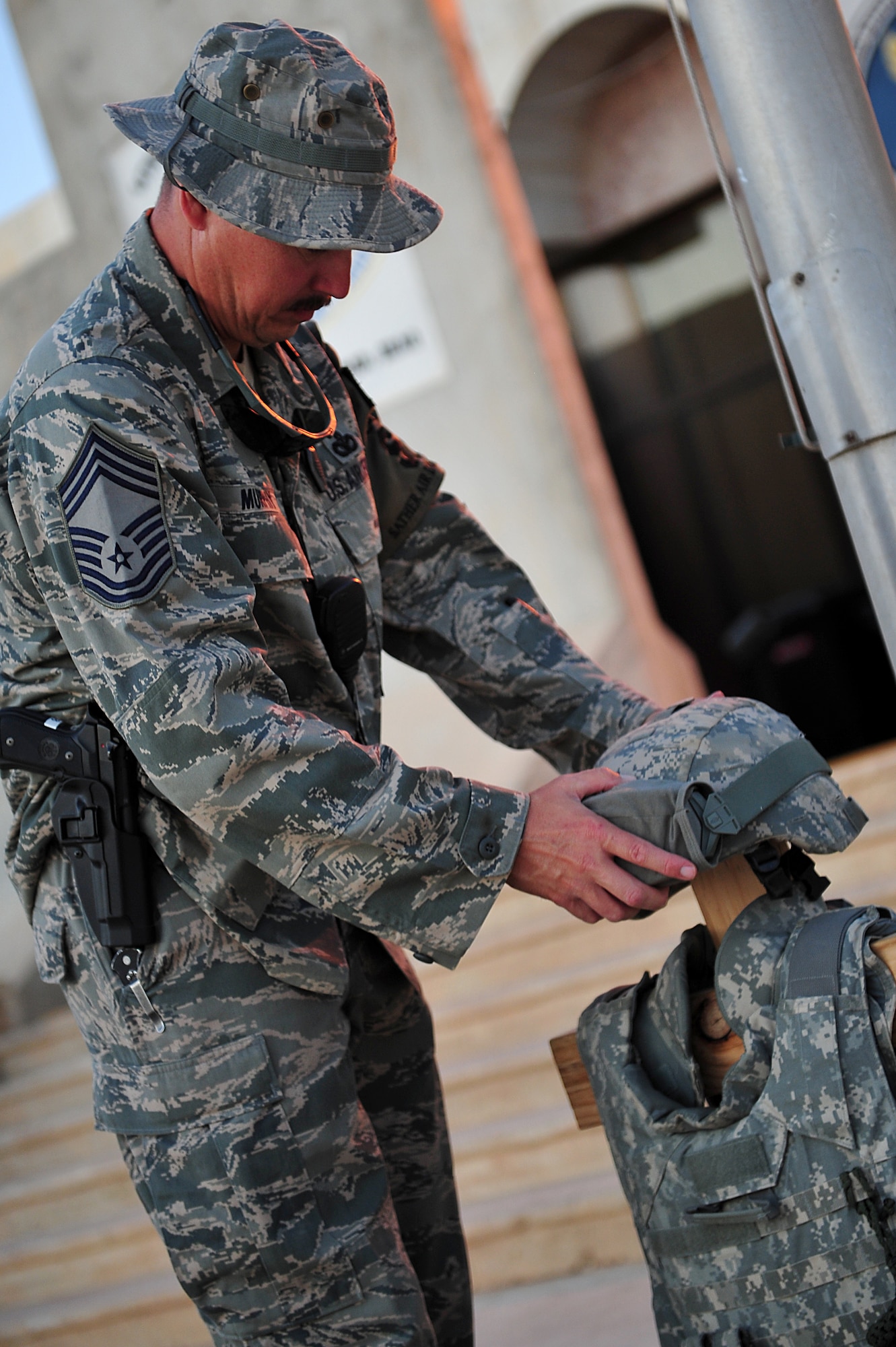 Chief Master Sgt. Gary Murphy sets up a display representing fallen security forces Airmen and policemen for flag folding ceremony immediately following a two-mile road march, honoring the 9/11 attacks tenth anniversary, at Sather Air Base, Iraq, Sept. 11, 2011. More than 100 Soldiers, Sailors, Airmen and civilians donned their body armor and took part in the march as the sun rose. (U.S. Air Force photo/Tech. Sgt. Josef Cole)