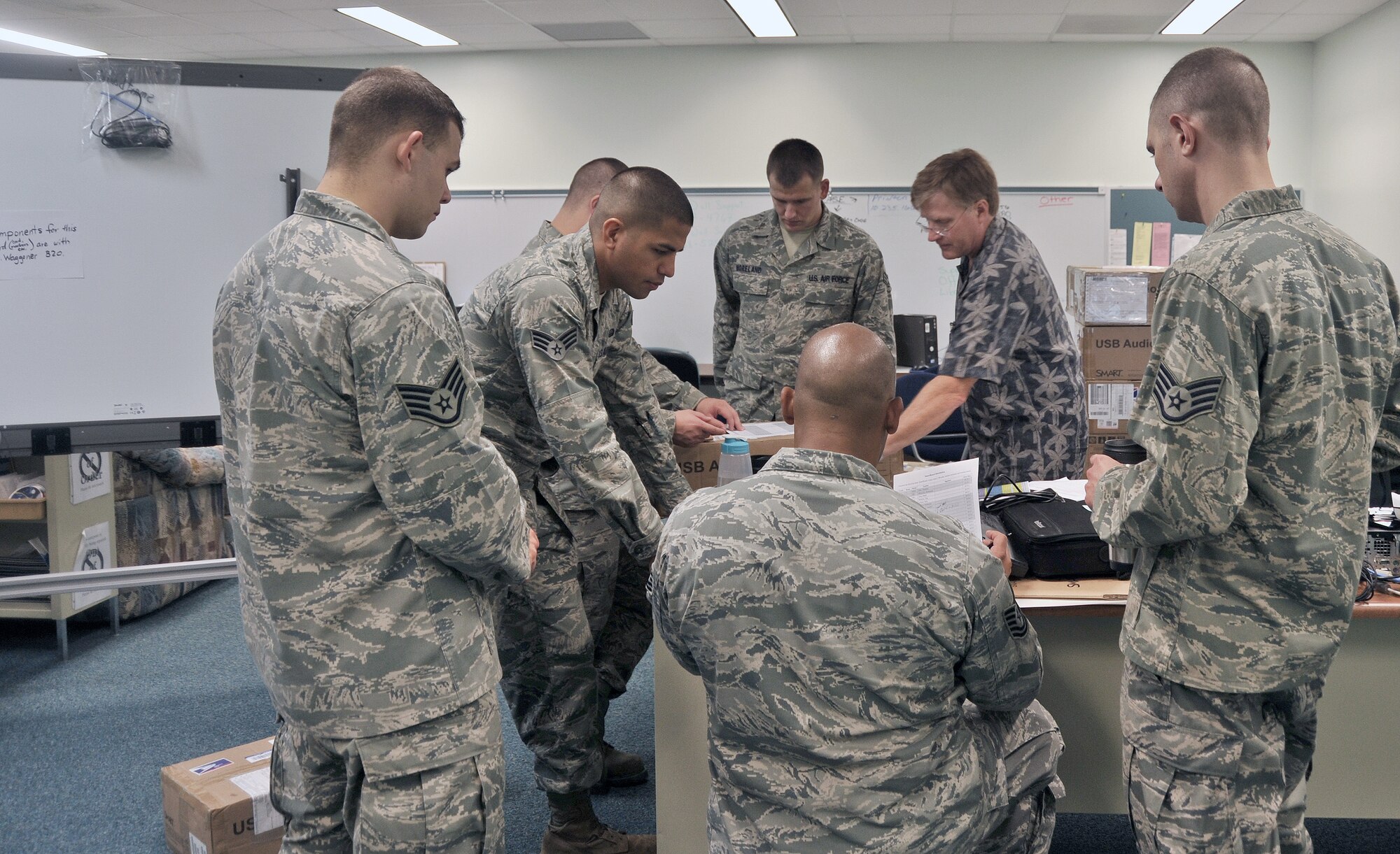 ANDERSEN AFB, Guam -- Airmen from the 644th Combat Communication Squadron plan out their Smart Board set up in the elementary school here Sept. 9. Volunteers from the 644 CBCS visited the Andersen Elementary School to setup a new computer lab and Smart Boards for students. (U.S. Air Force photo by Staff Sgt. Alexandre Montes)