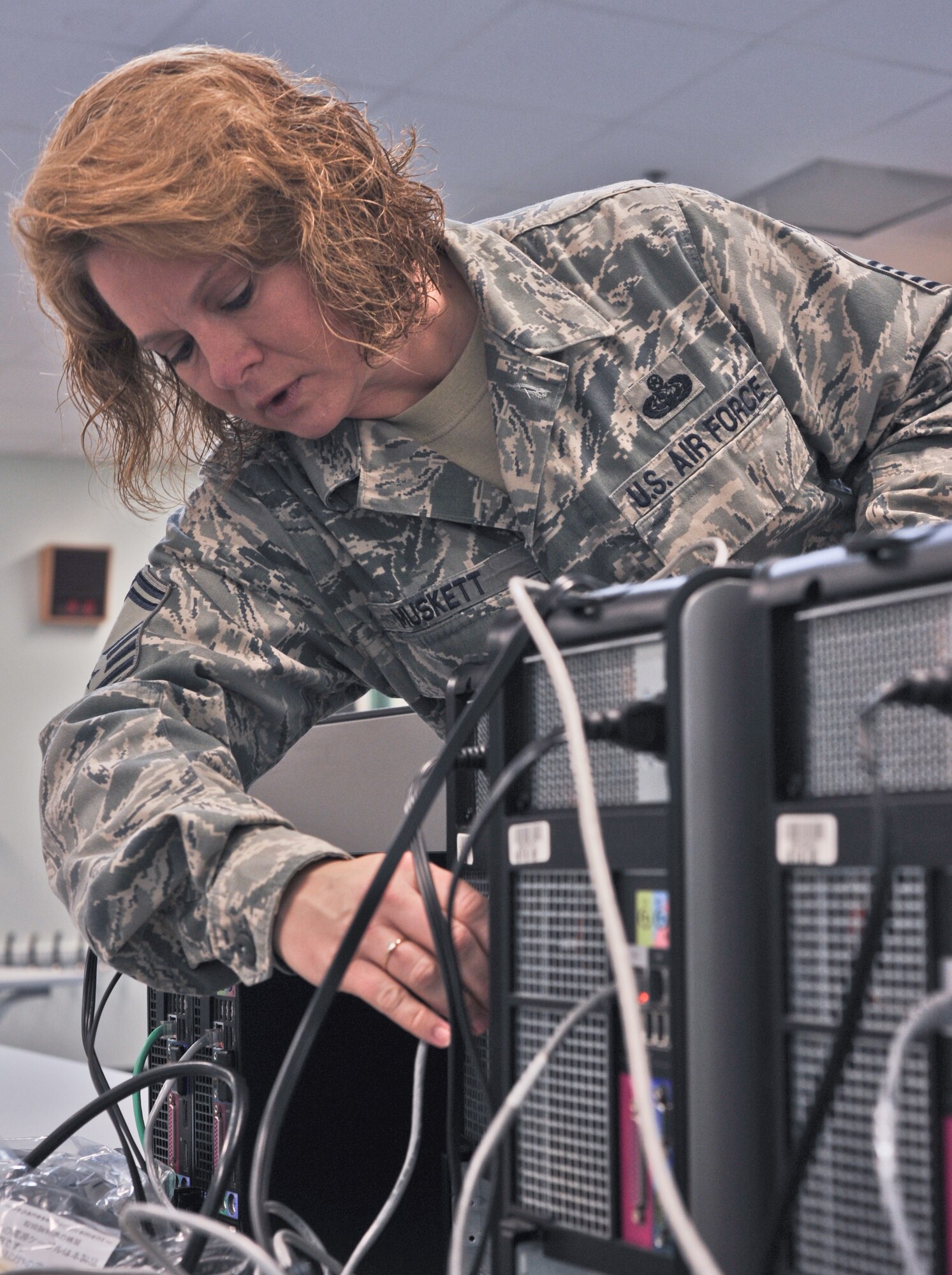 ANDERSEN AFB, Guam --Senior Master Sgt. Dawn Muskett, 644th Combat Communications Network Operations Flight superintendent, sets up a computer station at the elementary school here Sept. 9. Volunteers from the 644 CBCS visited Andersen Elementary School to setup a new computer lab and Smart Boards for students. (U.S. Air Force photo by Staff Sgt. Alexandre Montes)