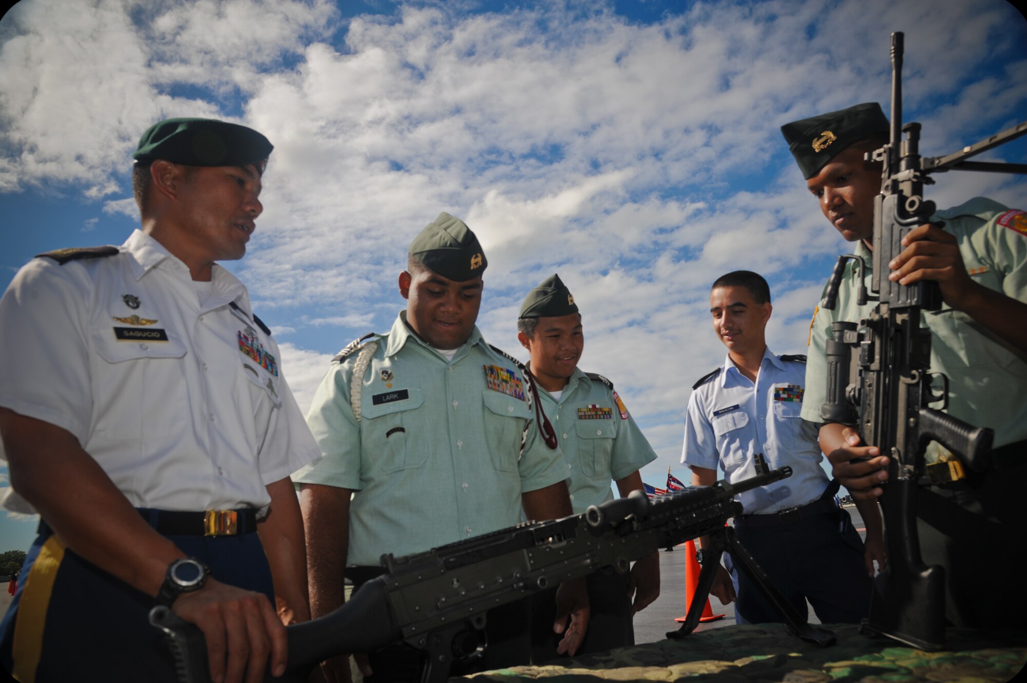 Army and Air Force Junior Reserve Officer's Training Corps cadets handle weapons at the 647th Security Forces Squadron combat arms table at the annual drill competition held on the Hickam Field flightline, Sept. 10. More than 300 JROTC cadets, from more than 14 high schools on Oahu attended the event. (U.S. Air Force photo/Senior Airman Lauren Main)