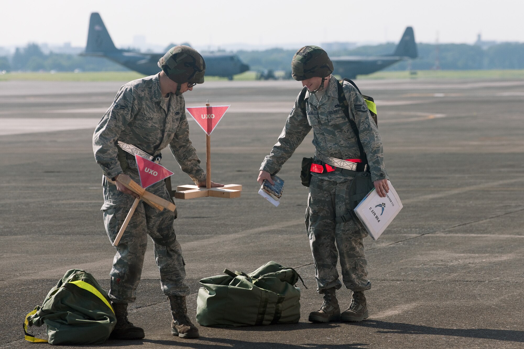 YOKOTA AIR BASE, Japan -- Airman 1st Class Jake Luckt (left) and Staff Sgt. Anthony Miller (right), both from the 374th Maintenance Squadron, set up an unexploded ordnance cordon at Yokota Air Base, Japan, Sept. 13, 2011 during a wing readiness exercise. (U.S. Air Force photo/Osakabe Yasuo)