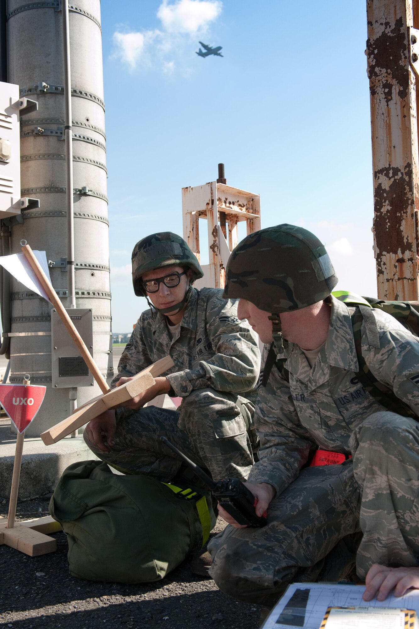 YOKOTA AIR BASE, Japan -- Airman 1st Class Jake Luckt (left) and Staff Sgt. Anthony Miller (right), both from the 374th Maintenance Squadron, set up an unexploded ordnance cordon at Yokota Air Base, Japan, Sept. 13, 2011 during a wing readiness exercise. (U.S. Air Force photo/Osakabe Yasuo)