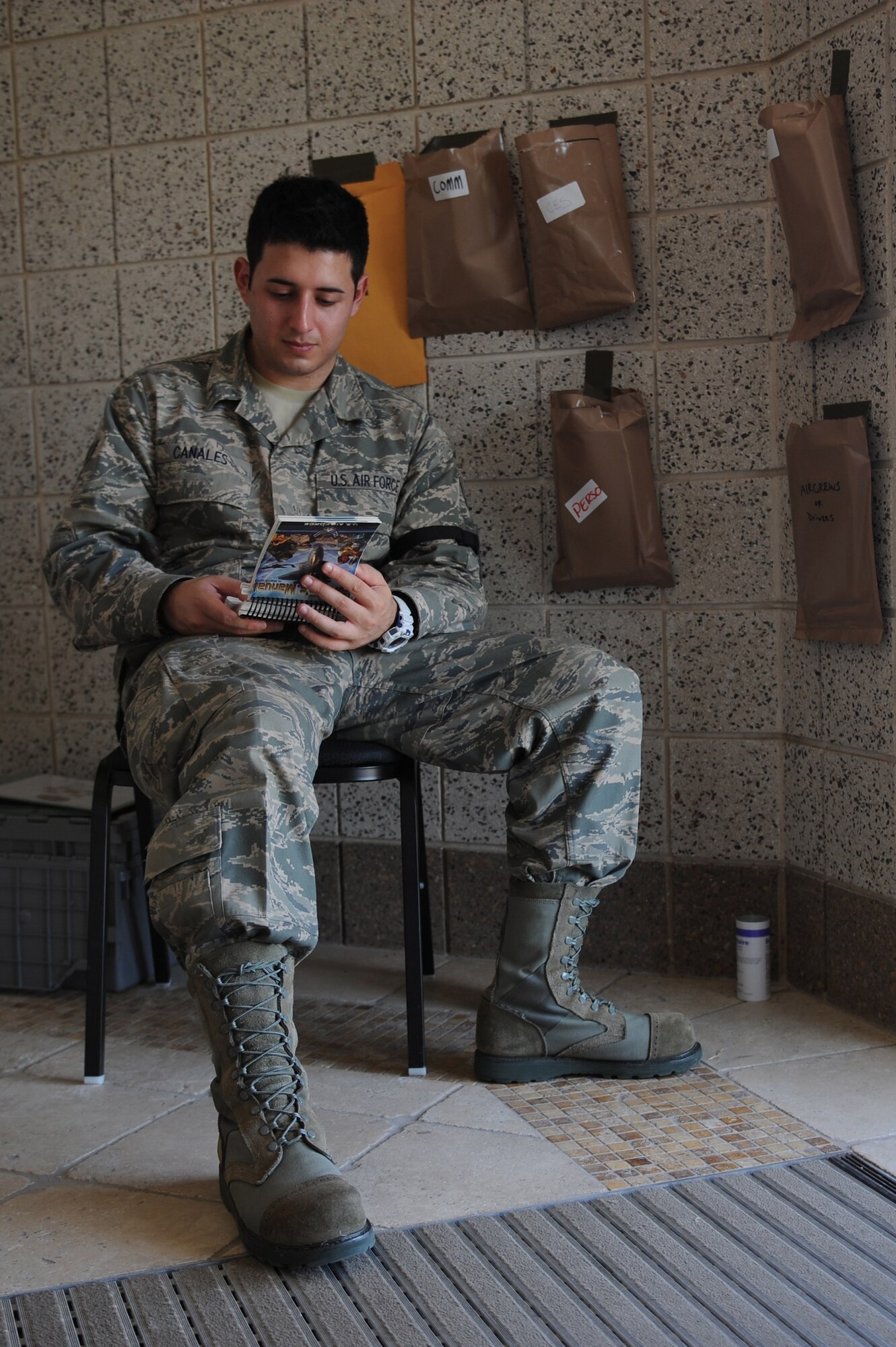 Senior Airman Marco Canales, a 19th Force Support Squadron career management specialist, reviews his Airman's Manual Sept. 10, 2011, at an entry-control point at volk Field, Wis. Little Rock AFB Airmen are participating in an operational readiness exercise to prepare for an upcoming operation readiness inspection in October.