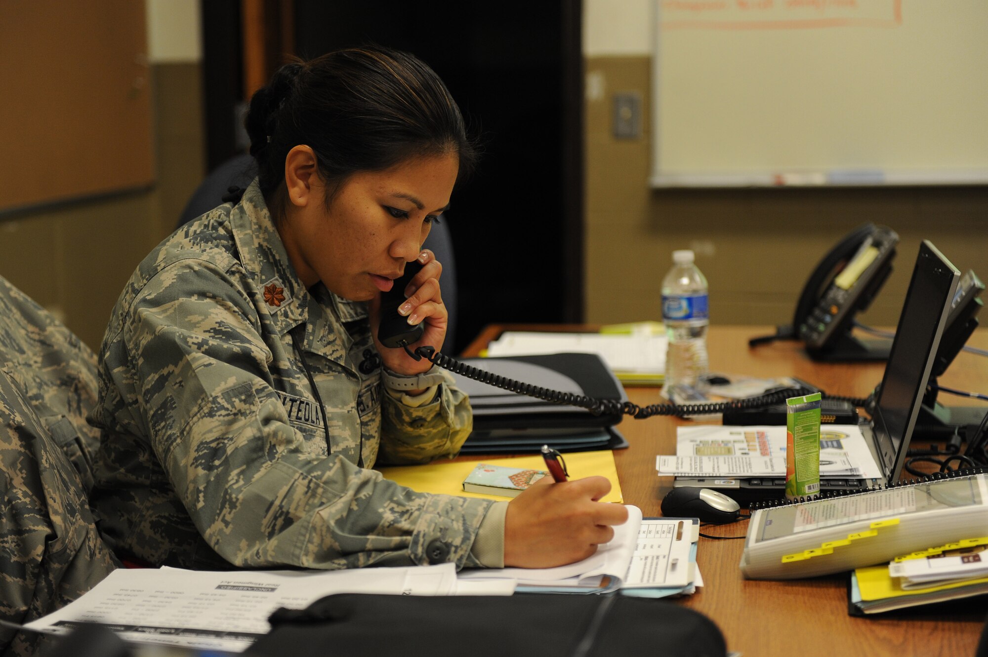 Maj. Veronica Anteola, a 19th Force Support Squadron emergency operation center representative, exchanges information for contingency operations with the 19th FSS unit control center Sept. 10, 2011, at Volk Field, Wis. The 19th FSS UCC is responsible for information concerning lodging, mortuary affairs, dining facilities and personnel support during the operation readiness exercise. 
