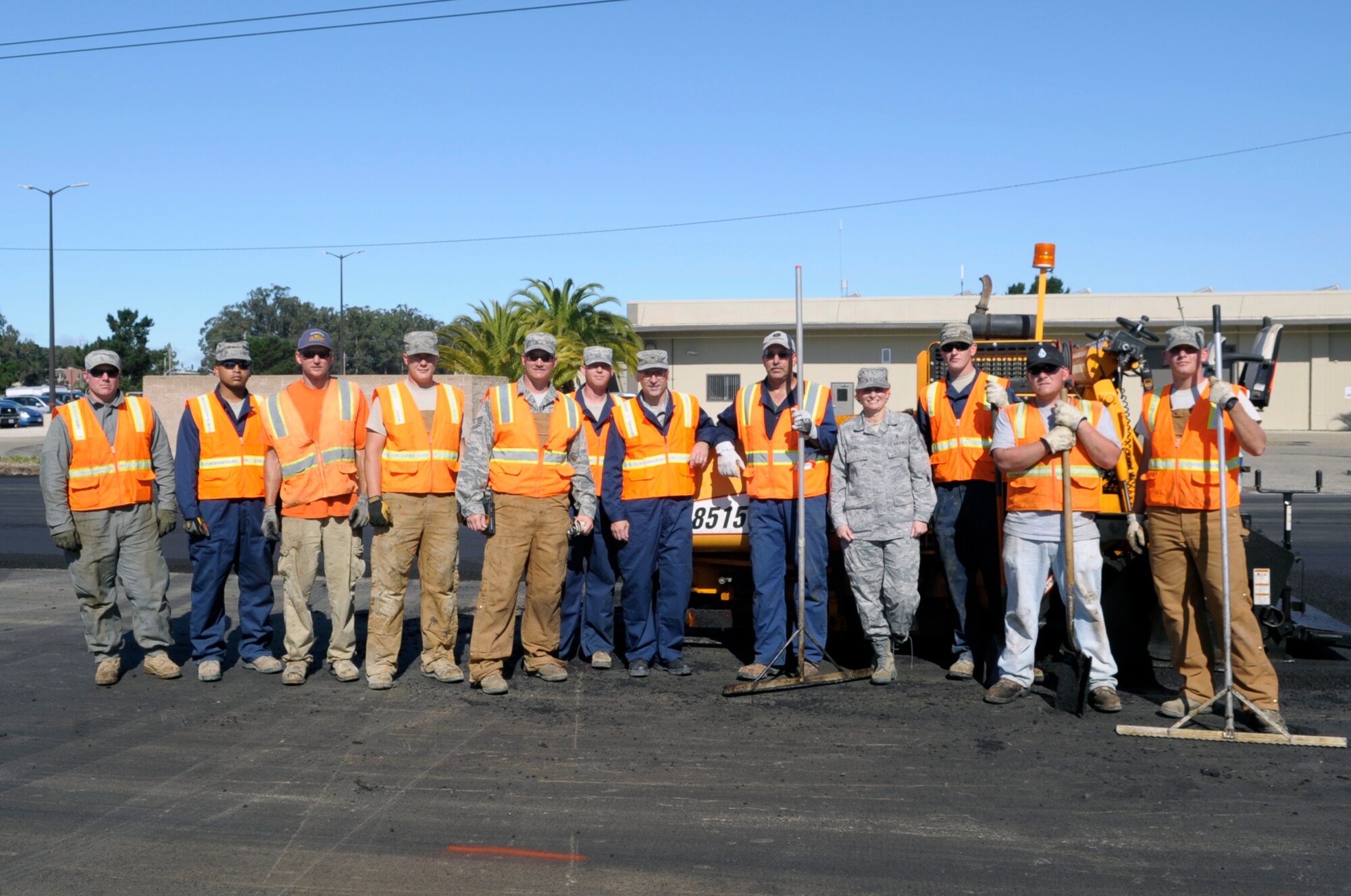 VANDENBERG AIR FORCE BASE, Calif. -- Col. Richard Boltz, 30th Space Wing commander, and Chief Master Sgt. Michelle Sobel, 30th SW acting command chief, take a moment for a group shot with the “Dirt Boys” while paving a parking lot at the 30th Civil Engineer Squadron compound parking lot here Wednesday, Aug. 24, 2011. (U.S. Air Force photo/Jerry E. Clemens, Jr.)