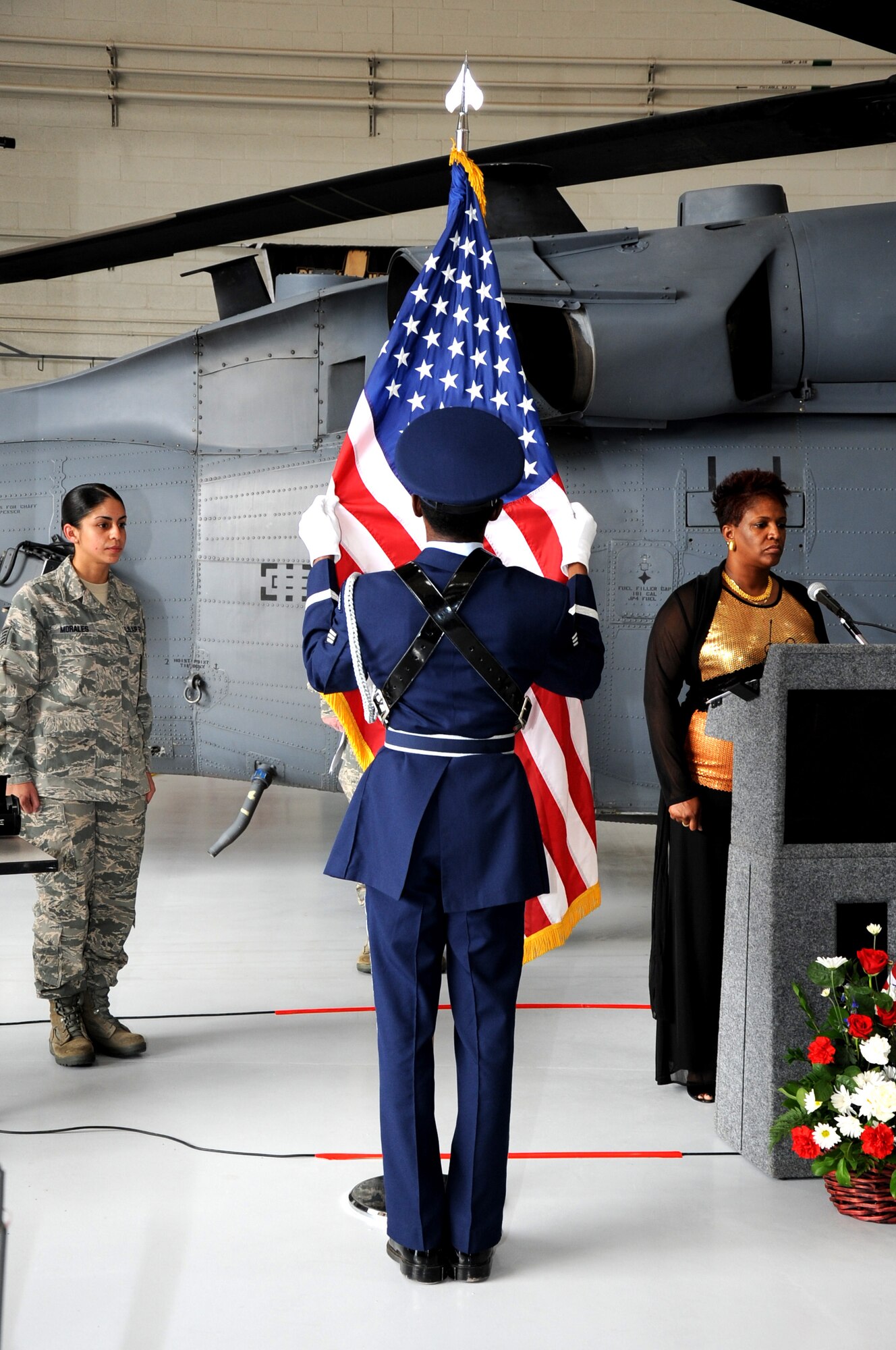 A member of the Davis-Monthan Air Force Base Honor Guard dresses the American flag during the 943rd Rescue Group's September 11th Remembrance Ceremony. The presiding officer of the ceremony, Lt. Col. John Beatty, 943rd RQG deputy commander, spoke of how the events of Sept. 11 united our nation and galvanized our armed force into action.  (U.S. Air Force Photo/ Tech. Sgt. Luke Johnson) 
