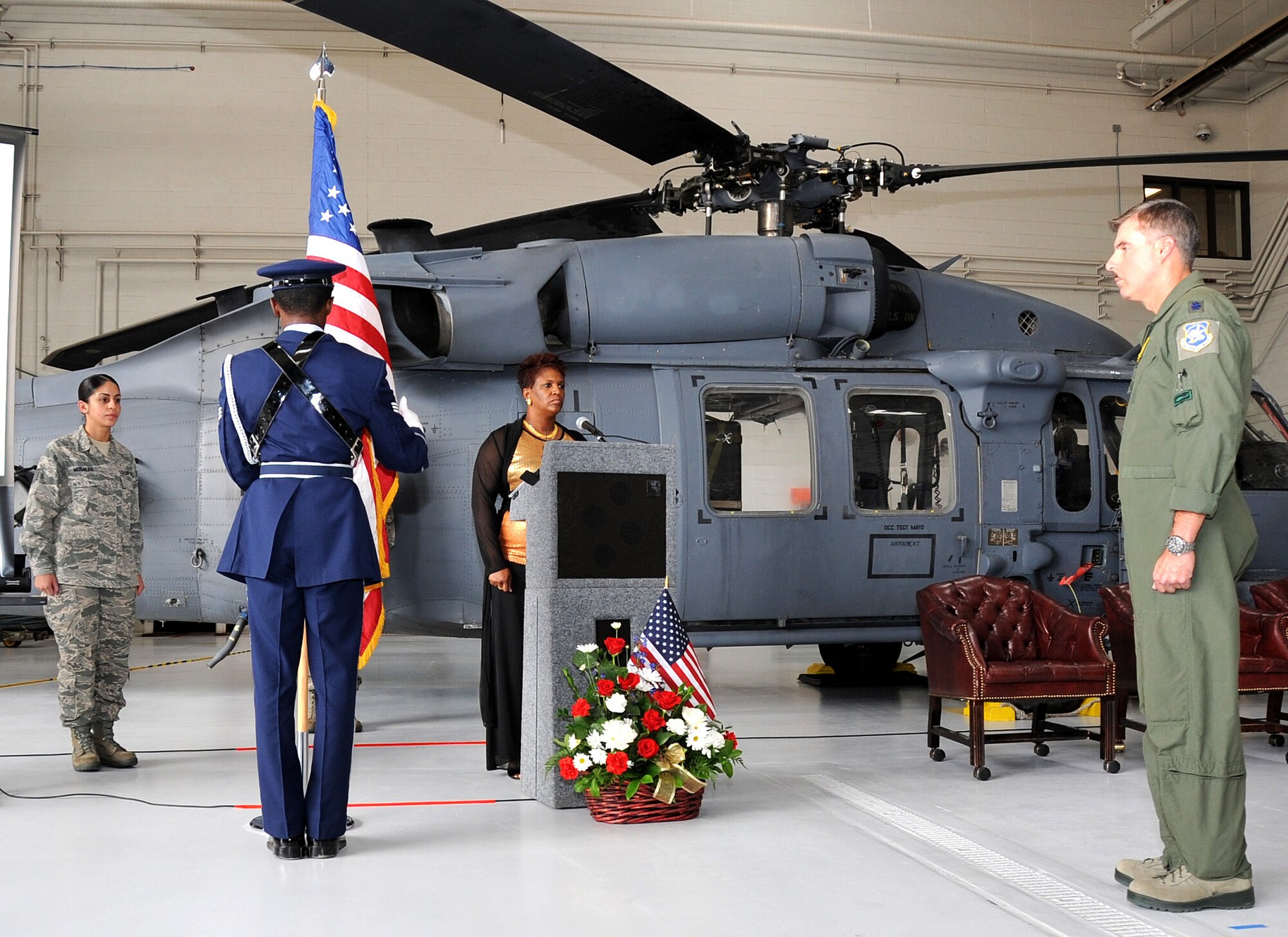 A member of the Davis-Monthan Air Force Base Honor Guard dresses the American flag as Lt. Col. John Beatty, 943rd Rescue Group Commander deputy commander, stands at attention during the 943rd RQG September 11th Remembrance Ceremony. Colonel Beatty spoke of how the events of Sept. 11 united our nation and galvanized our armed force into action.  (U.S. Air Force Photo/ Tech. Sgt. Luke Johnson)