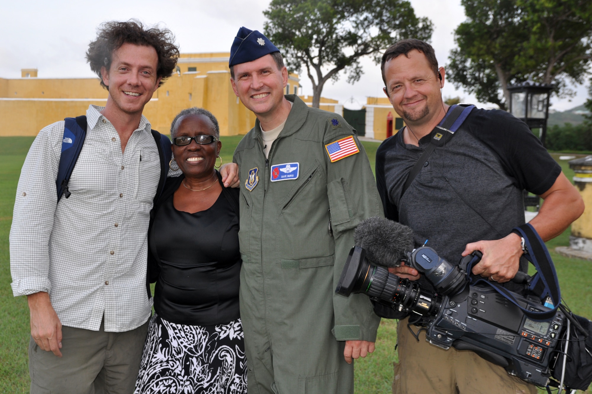 Christian D'Andrea, executive producer with Story Foundry and Andy McDonald, senior videographer with High Noon Entertainment  stand with Lt. Col. Dave Borsi, 53rd Weather Reconnaissance Squadron pilot, and Maria, a resident of St. Croix. D'Andrea and McDonald were in St. Croix to film the Hurricane Hunters as part of the television series they are making about the squadron. While there to film the squadron's missions into Tropical Storm Maria, they and Borsi met native Maria in downtown Christianstead.  (U.S. Air Force photo by Staff Sgt. Valerie Smock)