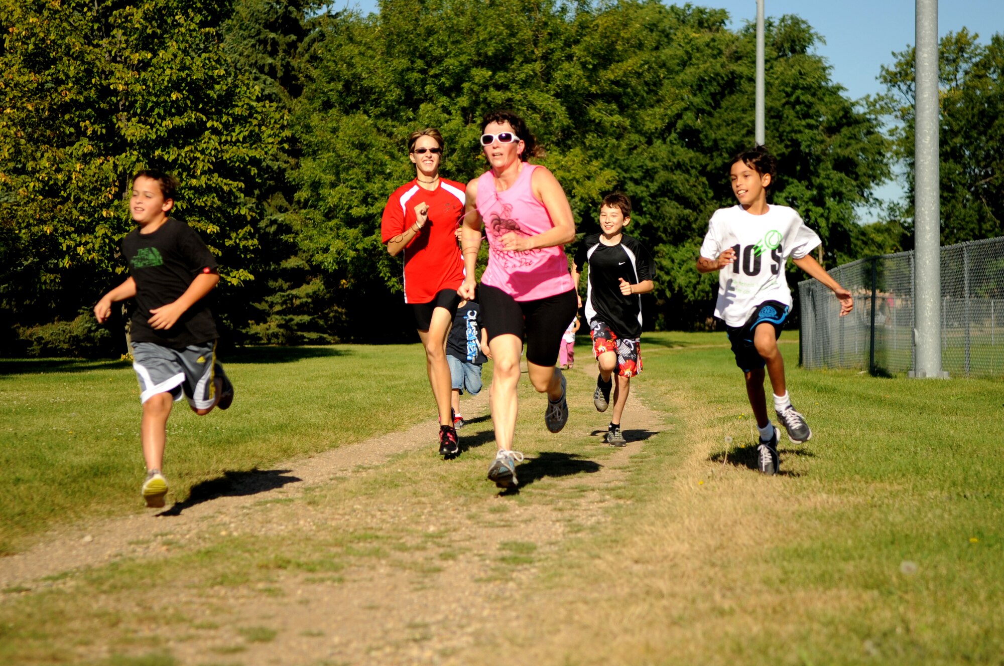 Jane Hutzol, 319th Air Base Wing Chapel, finishes strong with the children she trained all summer for the triathlon on Grand Forks Air Force Base Sep 10. GFAFB sponsored a sprint triathlon which consisted of a 750m swim, 12km bike ride and a 5km run. (U.S Air Force photo by Senior Airman Amanda N. Stencil)