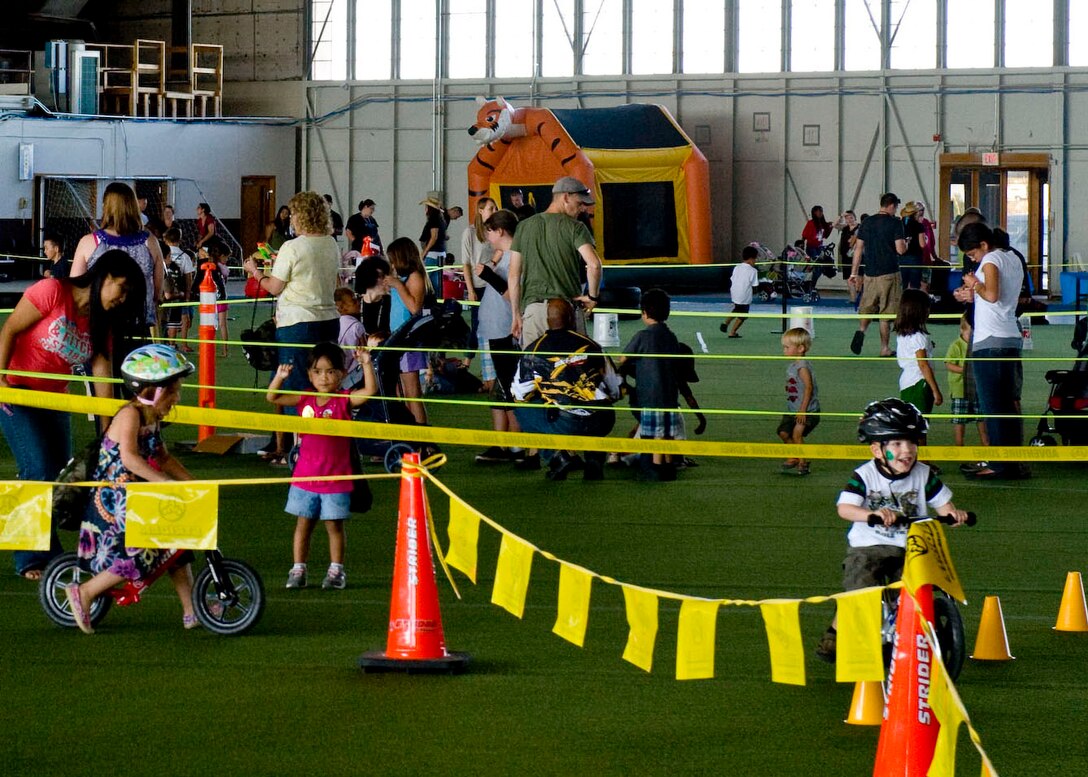 Families gather in the Pride Hangar to kick off the new school year during the Back to School Roundup on Ellsworth Air Force Base, S.D., Sept. 10, 2011. The event consisted of music, games, martial arts demonstrations, face-painting, bouncy castles and prizes for all ages. (U.S. Air Force photo by Master Sgt. Charles Stansbury/Released)