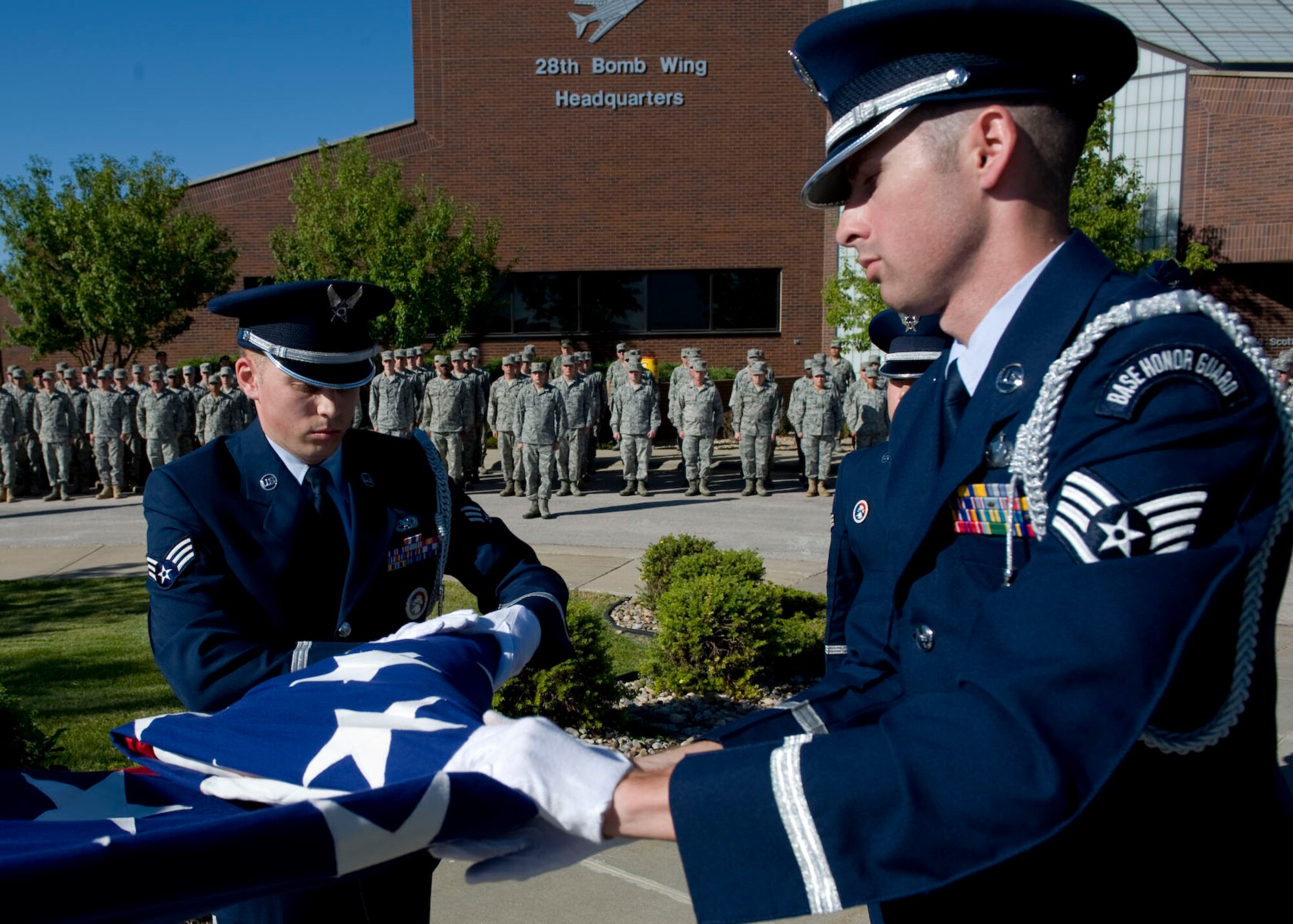 Senior Airman David Carter and Staff Sgt. Thomas Waters, Airmen from the Ellsworth Air Force Base Honor Guard, fold the flag at the POW/MIA and 9/11 Remembrance Retreat Ceremony in front of the 28th Bomb Wing Headquarters on Ellsworth Air Force Base, S.D., Sept. 9, 2011. Airmen from every Ellsworth group formed into flights outside the headquarters building to pay homage to the flag during this significant event. (U.S. Air Force photo by Airman 1st Class Kate Thornton/Released)