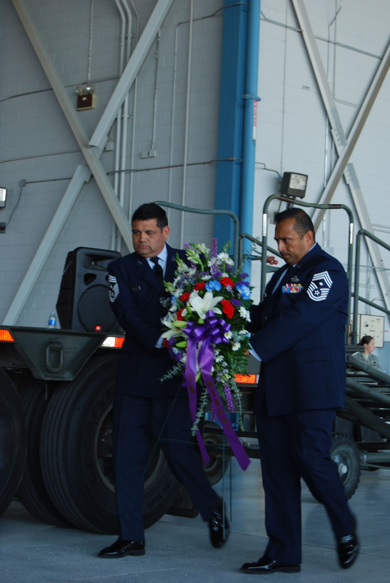 Chief Master Sgt. Emil Garza, 433rd AIrlift Wing command chief, and Chief Master Sgt. Gil Morales, 433rd Aircraft Maintenance Squadron first sergeant, brought forward a floral arrangement during the ceremony commemorating the 10th anniversary of September 11th. The ceremony included a bell sounding for each year since the attacks and the playing of Taps. (U.S. Air Force photo/Senior Airman Viola Hernandez)