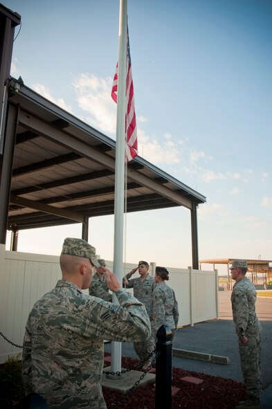 A flag detail salutes the flag as it is lowered to half staff during the 9-11 memorial ceremony on Moody Air Force Base, Ga. on Sept. 11, 2011. The ceremony honored the 2,977 men and women who lost their lives during the event. Of the 2,977, 343 were New York City Firefighters; 23 New York City police officers; 37 Port Authority police officers; and 15 New York City Fire Department and EMT's and paramedics.  (U.S. Air Force photo by Staff Sgt. Joshua J. Garcia/Released)