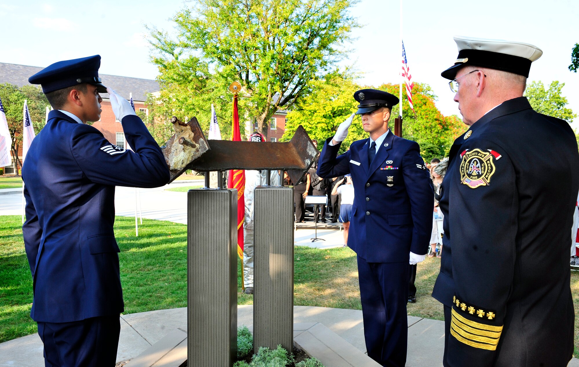 Airman 1st Class Stephen Mcnulty and Staff Sgt. Solomon Rigsby, 375th Civil Engineer Squadron fire protection, salute the completed Scott Air Force base 9/11 memorial. The memorial was created for Team Scott and visitors to remember fellow Americans who died on 9/11. The Scott monument is made of four pieces: a pentagon shaped-planter constructed of Indiana limestone--the same material used in the façade of the Pentagon. Within the planter, new foliage representing life is planted in soil from Pennsylvania; Twin Tower replicas emerge from the center, made of brushed steel in the same style as the fallen towers. And a steel beam from the Twin Towers. The monument now offers a place of reflection for families, military members and civilian guests. (U.S. Air Force photo, Staff Sgt. Stephenie Wade)