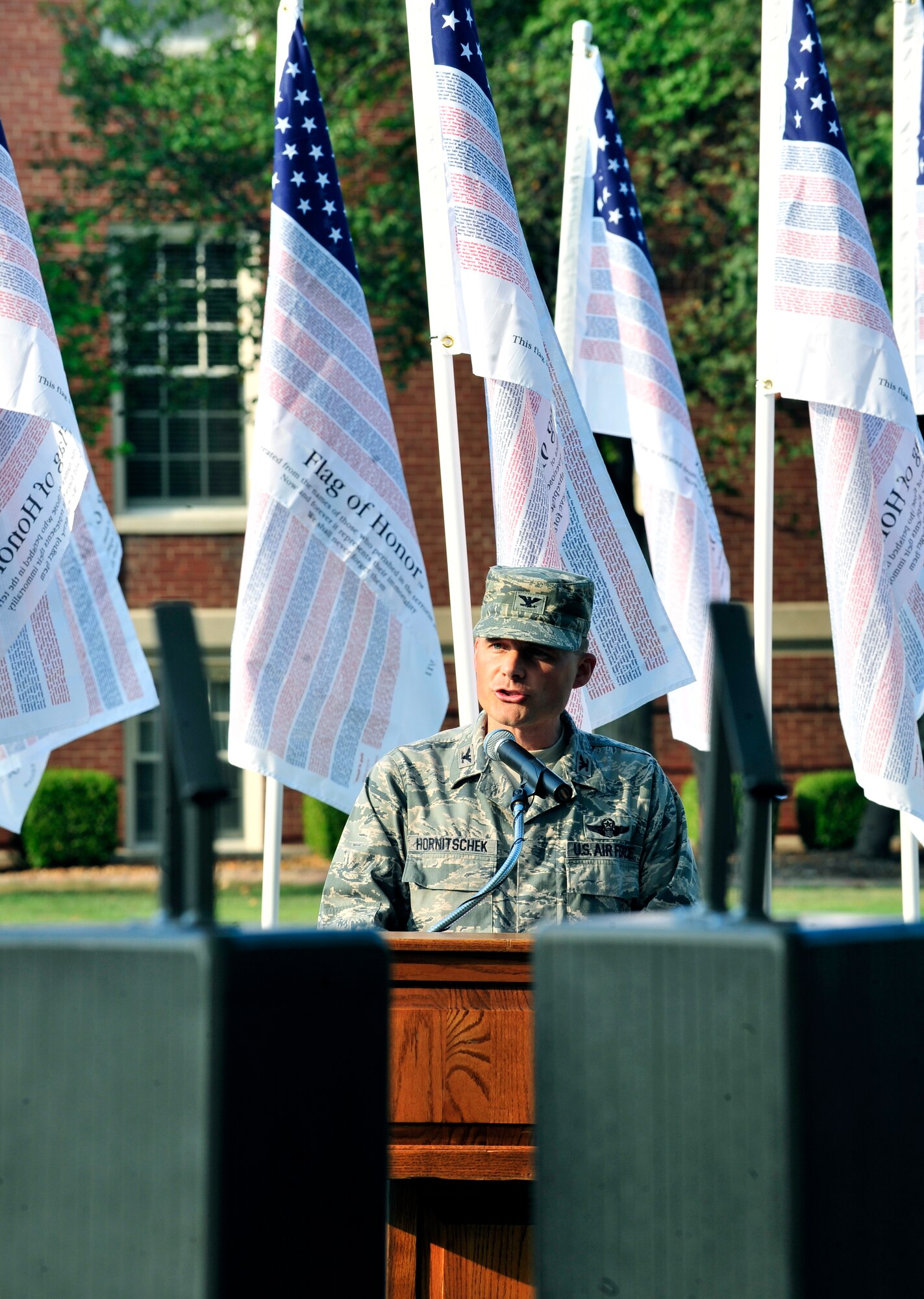 Col. Michael Hornitschek, 375th Air Mobility Wing commander, speaks during 9/11 observance ceremony on the 10th anniversary in front of the 375th Wing Headquarters building. Team Scott also held a 2 mile run where representatives from all five military branches took turns carrying the World Trade center steel beam until it was laid to rest atop the Scott AFB 9/11 monument. (U.S. Air Force photo, Staff Sgt. Stephenie Wade) 
