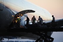 Load crews work to load 335th Fighter Squadron cargo onto a chartered aircraft that will take them to Afghanistan from Seymour Johnson Air Force Base, N.C., Sept. 10, 2011. For many Airmen, this is their first deployment, and many were not yet members of the Air Force when Sept. 11, 2001 occurred. (U.S. Air Force photo by Senior Airman Rae Perry)