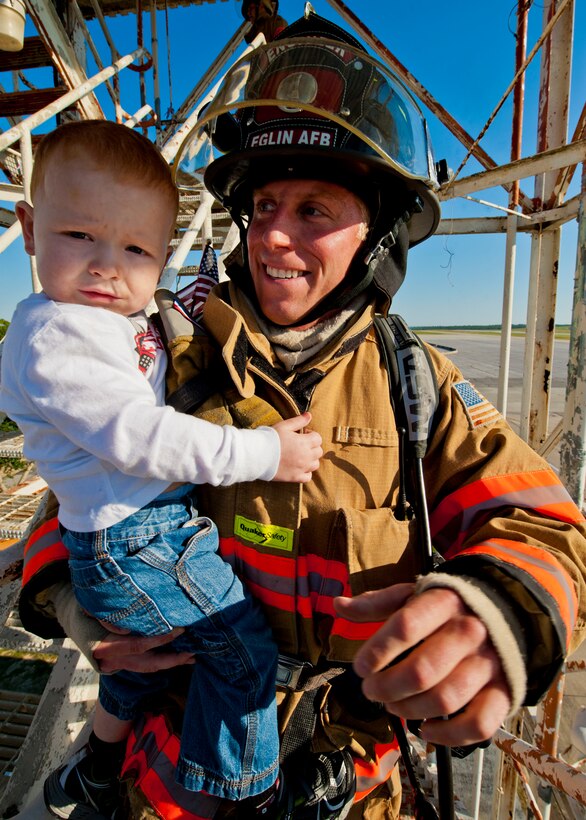 Braddock Becker gets a ride up to the top of the Duke Field air traffic control tower by Charles Conroy, a 96th Civil Engineer Squadron firefighter, during a 9/11 memorial stair climb at Duke Field, Sept. 11.  Thirteen firefighters commemorated the occasion by continuously climbing the steps of the ATC tower to simulate the 110-flight climb of the World Trade Center.  The firefighters hung red, white and blue streamers with the names of the 343 fallen firefighters along the tower as they climbed.  (U.S. Air Force photo/Tech. Sgt. Samuel King Jr.)