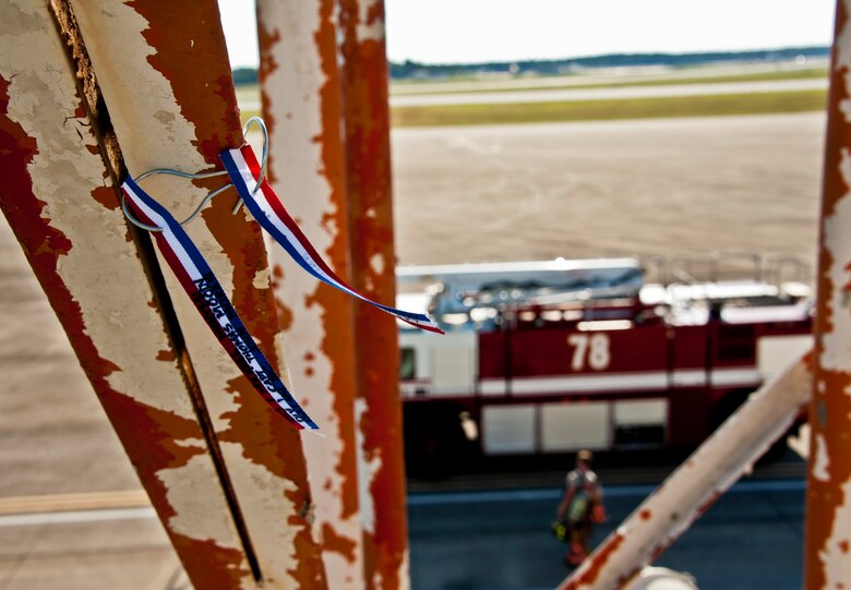 Two streamers sway in the morning breeze from the Duke Field air traffic control tower as a firefighter walks back to his fire engine after the first-ever 9/11 memorial stair climb at Duke Field, Sept. 11.  The firefighters commemorated the occasion by continuously climbing the steps of the ATC tower to simulate the 110-flight climb of the World Trade Center.  The firefighters hung red, white and blue streamers with the names of the 343 fallen firefighters along the tower as they climbed.  (U.S. Air Force photo/Tech. Sgt. Samuel King Jr.)