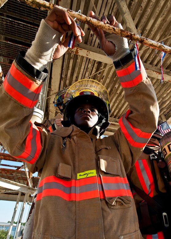 Airman 1st Class DeMichael Overstreet, a 96th Civil Engineer Squadron firefighter, attaches a streamer to the Duke Field air traffic control tower during a 9/11 memorial stair climb at Duke Field, Sept. 11.  Thirteen firefighters commemorated the occasion by continuously climbing the steps of the ATC tower to simulate the 110-flight climb of the World Trade Center.  The firefighters hung red, white and blue streamers with the names of the 343 fallen firefighters along the tower as they climbed.  (U.S. Air Force photo/Tech. Sgt. Samuel King Jr.)