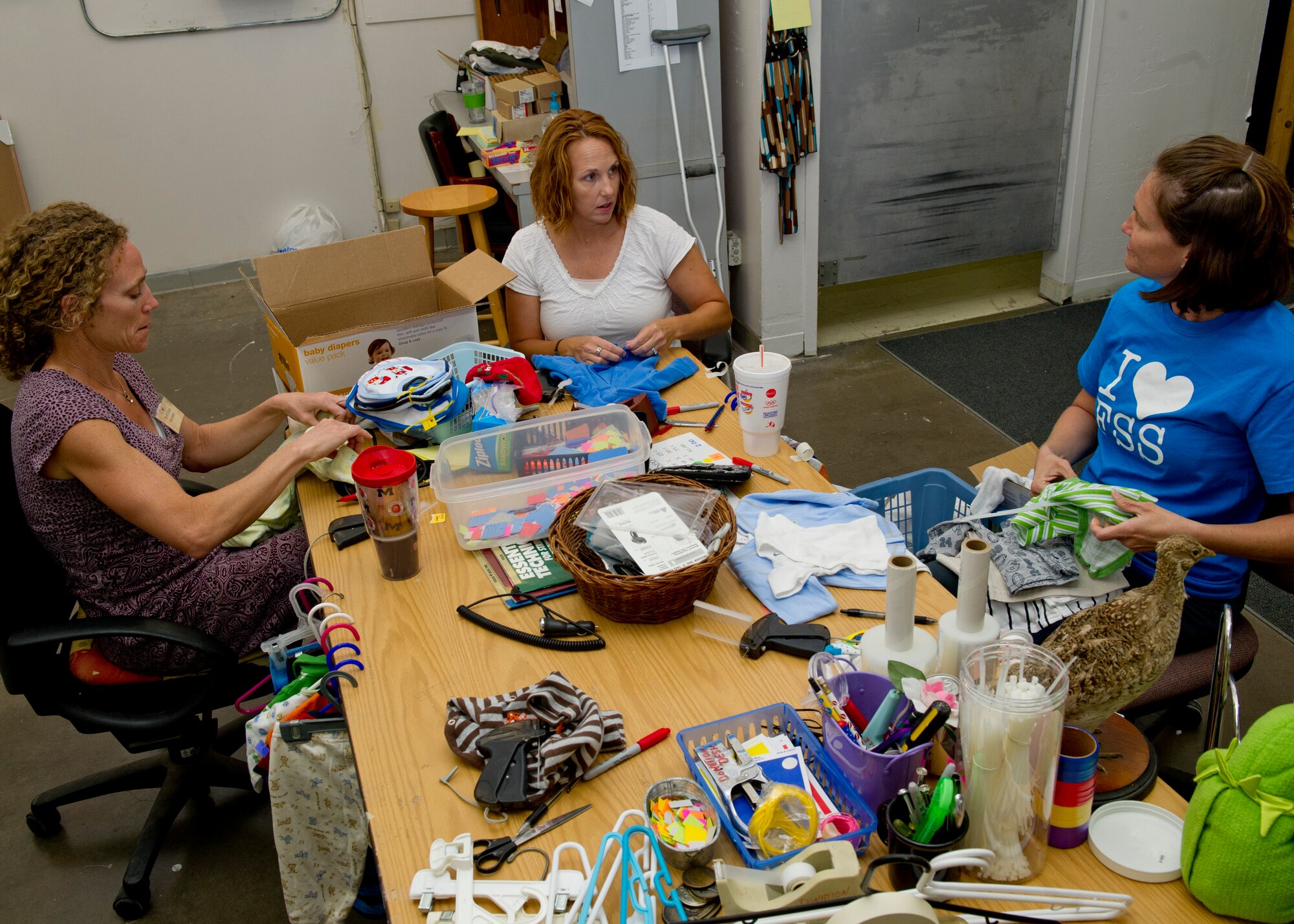 HOLLOMAN AIR FORCE BASE, N.M. -- Volunteers from the Holloman Officers’ Spouses’ Club sort through donated clothes Sept. 8, 2011, at the Thrift Store. Members from the HOSC meet twice a week to help run the shop and ensure the items up for resale are in good condition before putting them on the shelves. (U.S. Air Force photo by Senior Airman Veronica Stamps/Released)