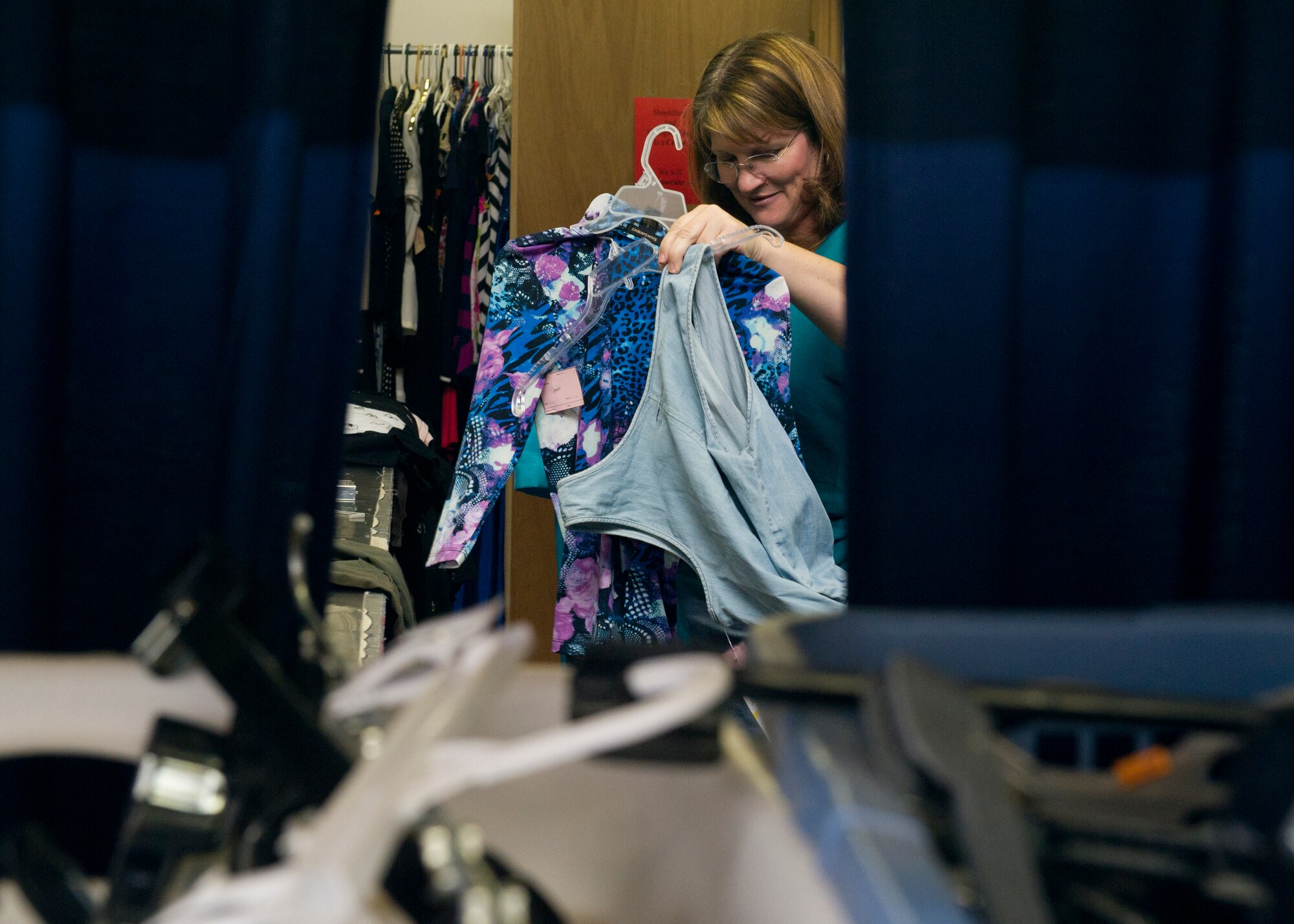 HOLLOMAN AIR FORCE BASE, N.M. -- Brenda Krajewski, wife of U.S. Air Force Col. James Krajewski, 49th Materiel Maintenance Group commander, hangs clothes Sept. 8, 2011, that were brought into the Thrift Store for resale. Members from the Holloman Officers’ Spouses’ Club meet twice a week to help run the shop and ensure the items up for resale are in good condition before putting them on the shelves. (U.S. Air Force photo by Senior Airman Veronica Stamps/Released)