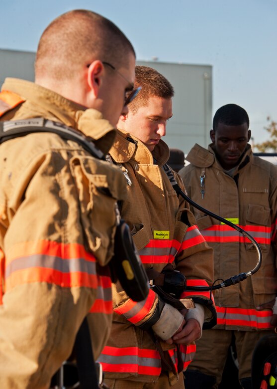 Firefighters with the 96th Civil Engineer Squadron, reflect on the day during a moment of silence held prior to a 9/11 memorial stair climb at Duke Field, Sept. 11.  Thirteen firefighters commemorated the occasion by continuously climbing the steps of the ATC tower to simulate the 110-flight climb of the World Trade Center.  The firefighters hung red, white and blue streamers with the names of the 343 fallen firefighters along the tower as they climbed.  (U.S. Air Force photo/Tech. Sgt. Samuel King Jr.)