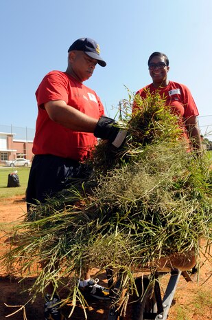 Master Chief  Petty Officer Terry Anthony and Chief Petty Officer Chiara White fill up a wheelbarrow with weeds  during the Trident United Way Day of Caring event, Sept. 9. More than 20 chiefs and chief selects spent the day restoring a baseball field at Baptist Hill Middle/High School. Anthony is the Naval Health Clinic  Charleston command master chief and Chiara is from the Naval Consolidated Brig Charleston. (U.S. Navy photo/Mass Communication Specialist 1st Class Jennifer Hudson) 