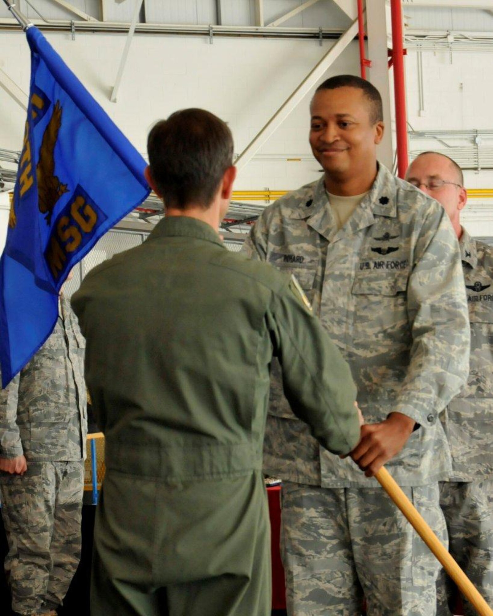 Lt. Col. Jeffery Richard (right), incoming 129th Rescue Wing Mission Support Group Commander, receives the MSG guidon from Col. Steven J. Butow, 129th Rescue Wing Commander, during the 129th MSG change of command ceremony at Moffett Federal Airfield, Calif., Sept. 10, 2011. (Air National Guard photo by Staff Sgt. Kim Ramirez)