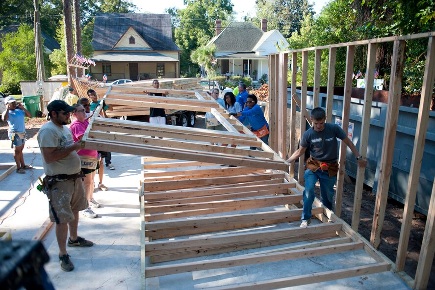 Volunteers from Moody Air Force Base, Ga., Valdosta State University and the Valdosta, Ga., community carry wall frames during day one of the 2nd Annual Valdosta-Lowndes County Habitat for Humanity Freedom Build in Valdosta Sept. 10, 2011. During last year’s Freedom Build, Moody volunteered more than 2,500 hours and saved more than $51,000 to help construct a four-bedroom for a Valdosta family. (U.S. Air Force photo by Staff Sgt. Jamal D. Sutter/Released) 