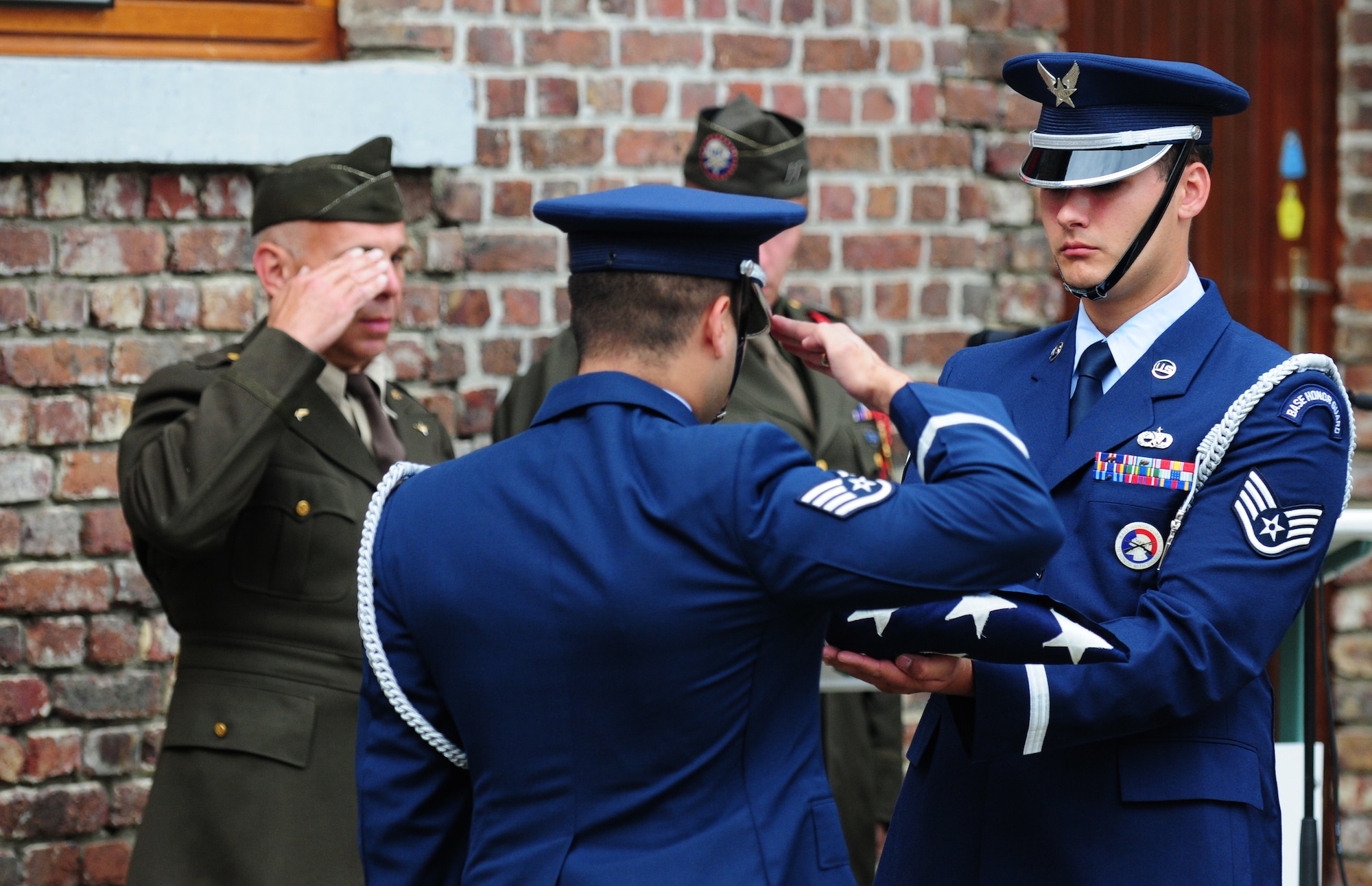 BORLO, Belgium – Staff Sgt. Victor Estupinan, 52nd Fighter Wing Honor Guard member, salutes the American Flag held by teammate Staff Sgt. Charles Lopez after performing a flag-folding ceremony during a Belgian 9-11 memorial ceremony here Sept. 11. U.S. service members and Belgian World War II Honor Guard Team members, along with the local community, participated in this ceremony as part of the Belgian Open Monument Day in remembrance of the victims of the Sept. 11, 2001 terrorist attacks on the United States. (U.S. Air Force photo/Airman 1st Class Matthew B. Fredericks)