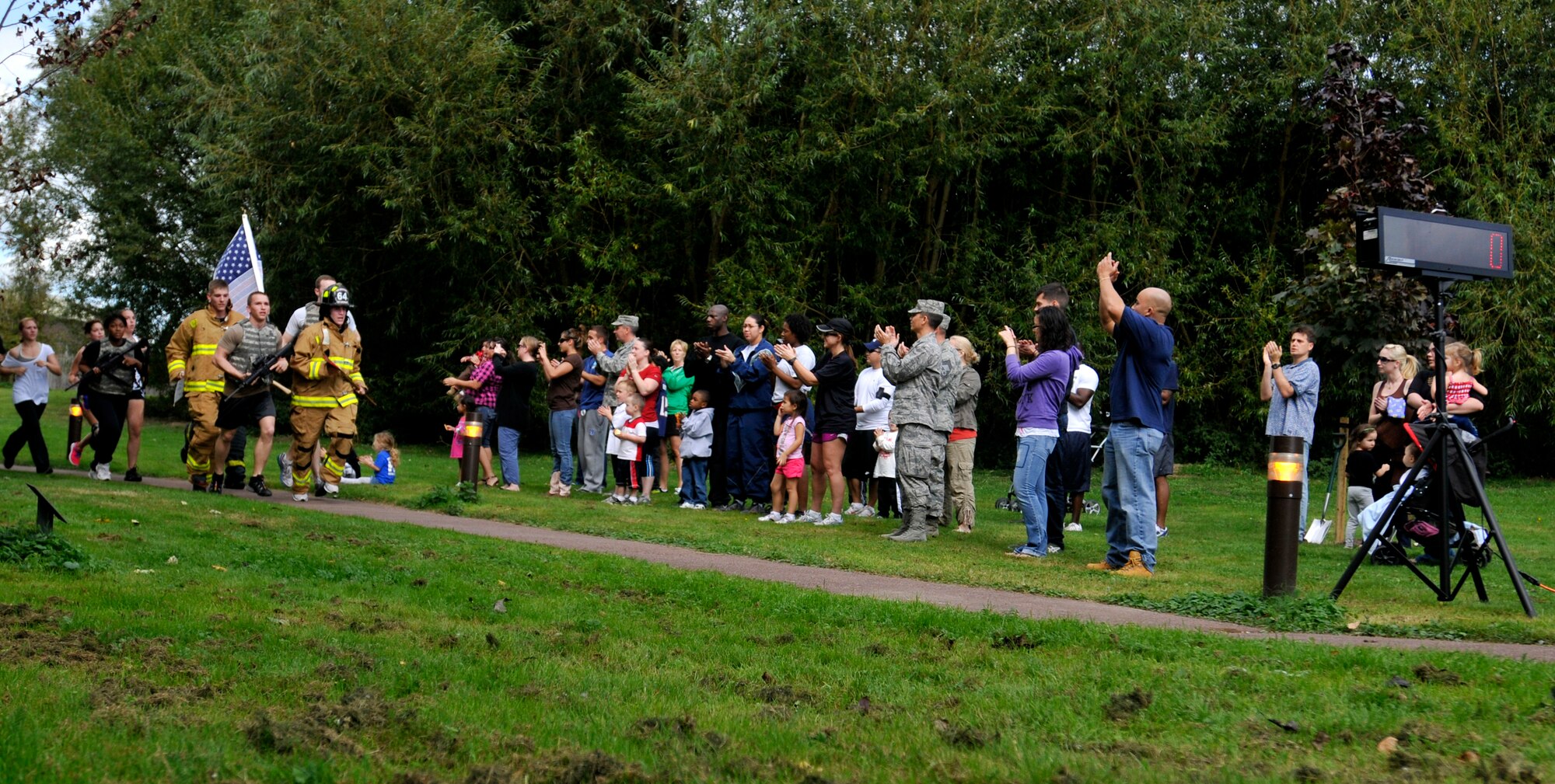 ROYAL AIR FORCE LAKENHEATH, England - Airmen and families cheer as Liberty Warriors finish the 24-hour Memorial Run at Peacekeeper Park, Sept. 10, 2011. The run, in remembrance of those that lost their lives in the 9/11 attacks, ended at 1:46 p.m. on Sept. 11, 2011, the time the first tower was hit. (U.S. Air Force photo by Senior Airman Tiffany M. Deuel)